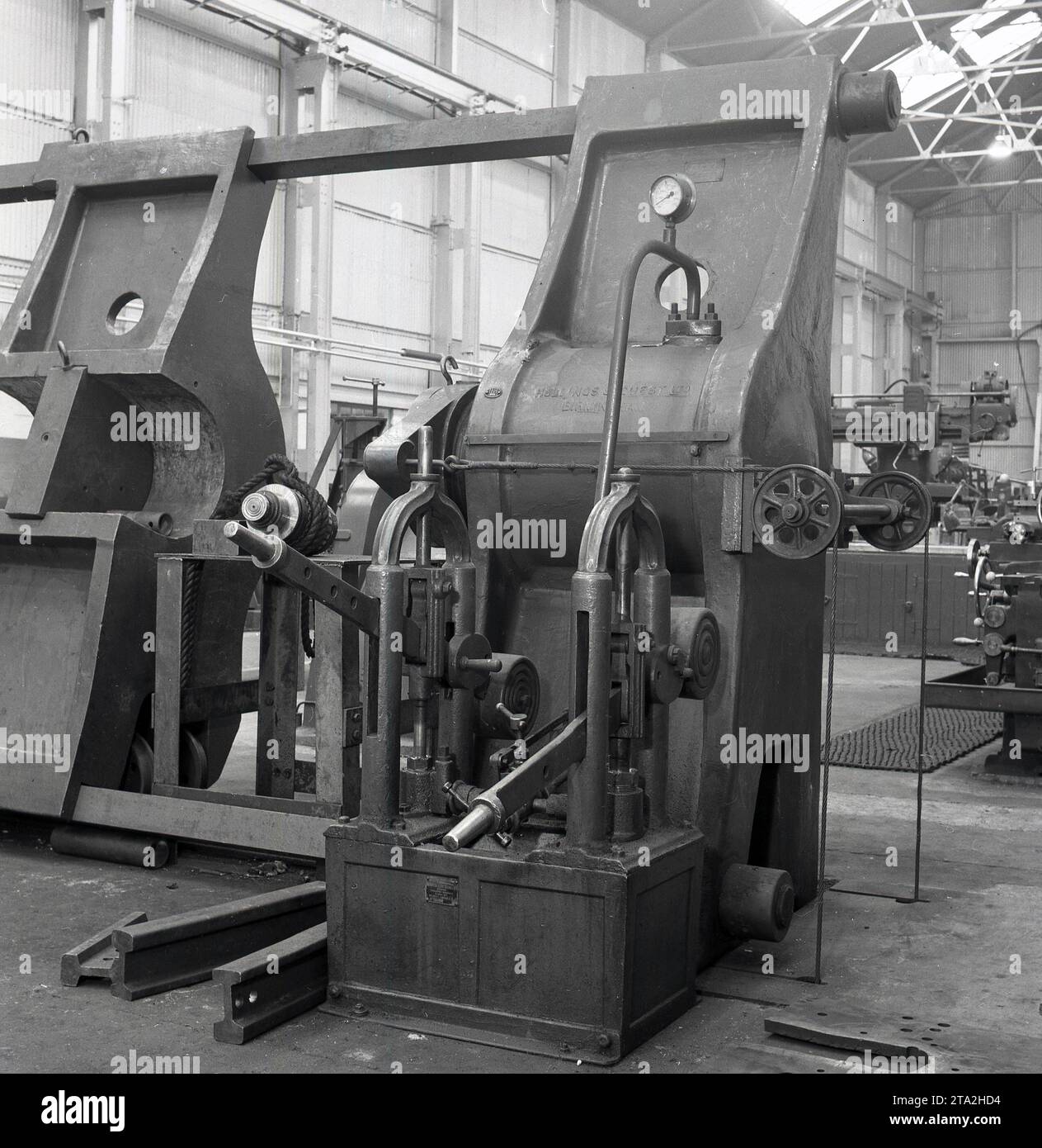 Années 1950, historique, à l'intérieur d'une aciérie, Abbey Works à Port Talbot, pays de Galles, Royaume-Uni, nous voyons une grande machine d'ingénierie en fonte, une presse hydraulique fabriquée par Hollings & Guest Ltd, de Thimble Mill Lane, Birmingham. Pâté sur la machine, n° 1101. Banque D'Images