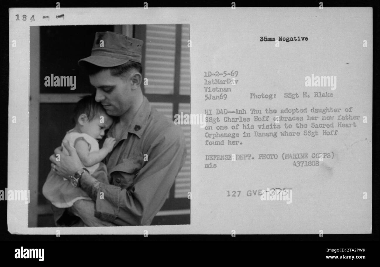 La jeune fille vietnamienne, Anh Thu, embrasse son nouveau père, le SSgt Charles Hoff, lors d’une de ses visites à l’orphelinat du Sacré-cœur à Danang, le 5 janvier 1969. Le Sgt Hoff a trouvé Anh Thu et l'a adoptée. Cette photographie a été prise par le Sgt H. Blake et fait partie de la documentation de la guerre du Vietnam par le corps des Marines des États-Unis. (Légende : DEPT. DÉFENSE PHOTO (MARINE CORPS) 4371808) Banque D'Images