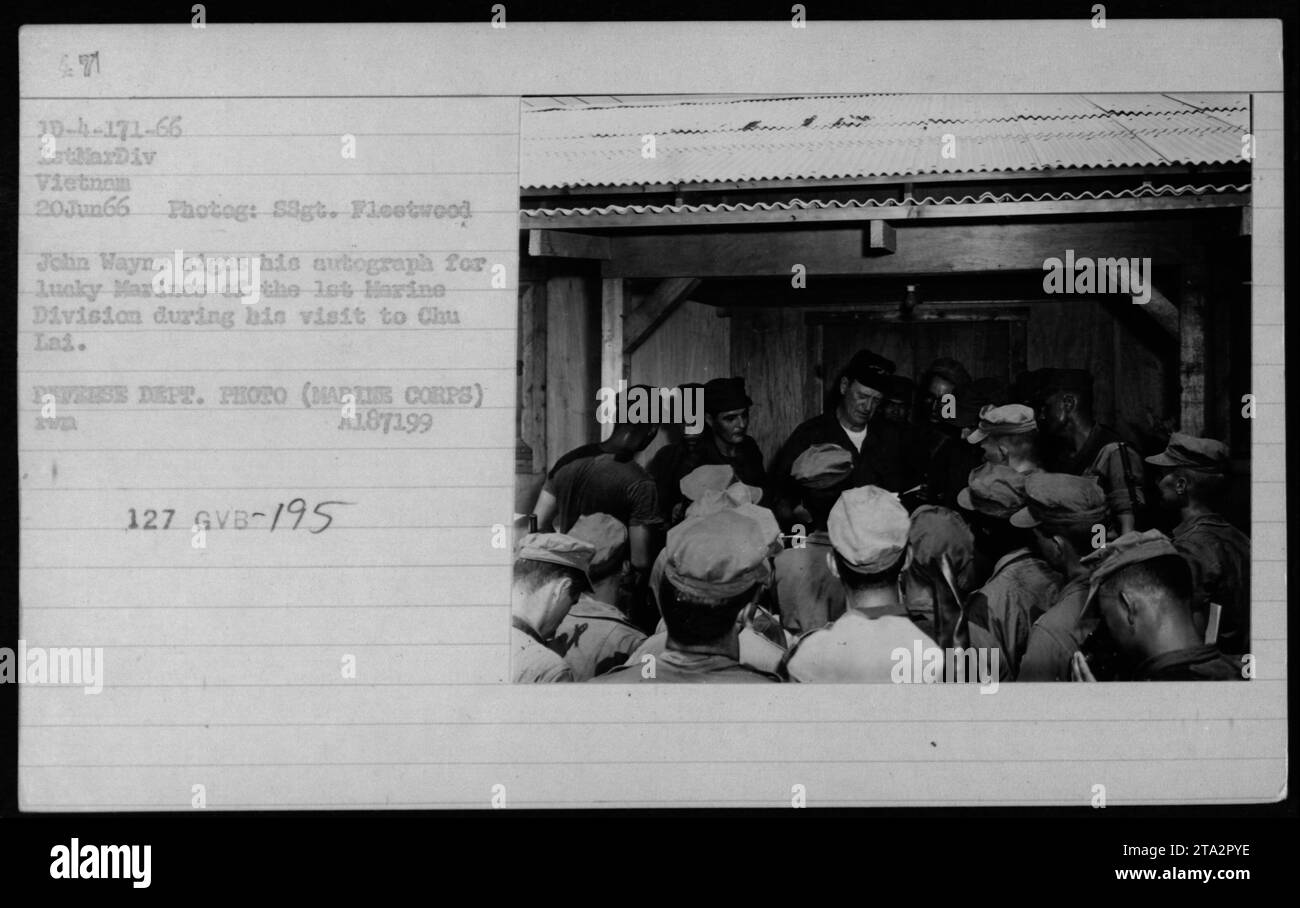 John Wayne signe un autographe pour les Marines de la 1e Division des Marines lors de sa visite à Chu Lai au Vietnam le 20 juin 1966. La photographie a été prise par Signalman Fleetwood et est une photo officielle du ministère de la Défense. Banque D'Images