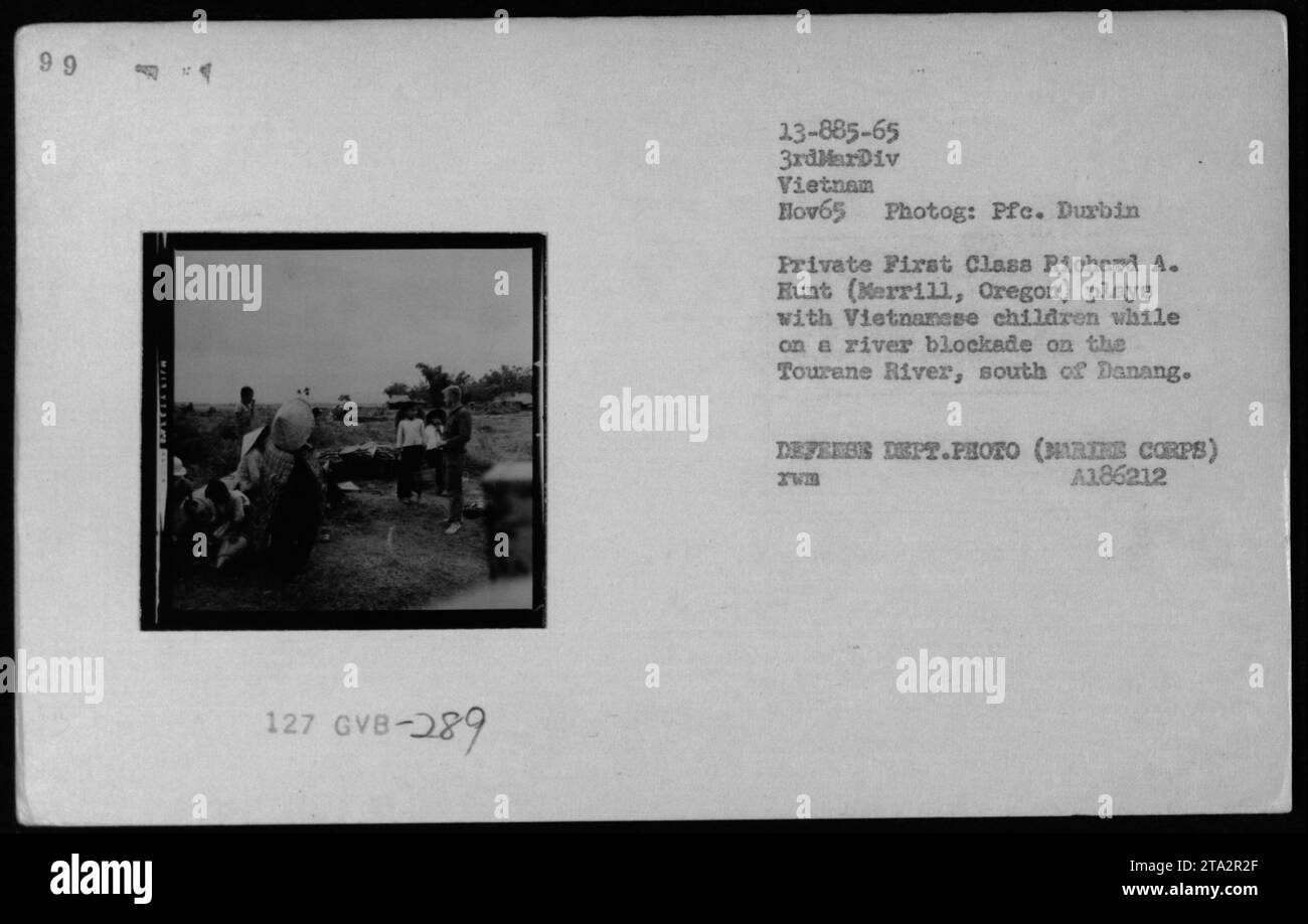 En novembre 1965, le PFC Richard A. Hunt de la 3e Division des Marines interagit avec des enfants vietnamiens lors d'un blocus fluvial sur la rivière Tourane au sud de Danang dans le cadre d'activités People to People. Banque D'Images