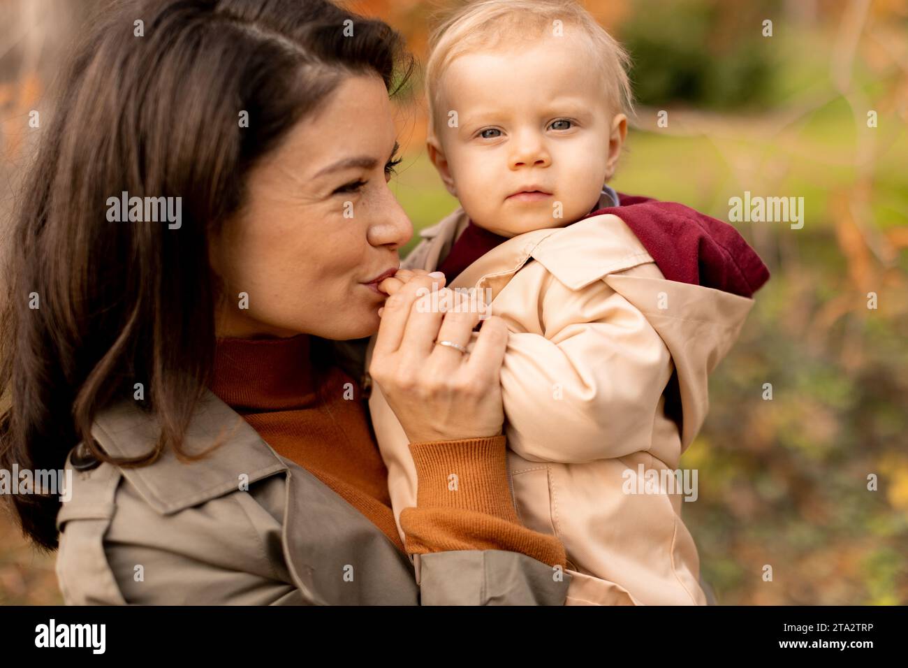 Jeune femme tenant une petite fille mignonne dans le parc d'automne Banque D'Images