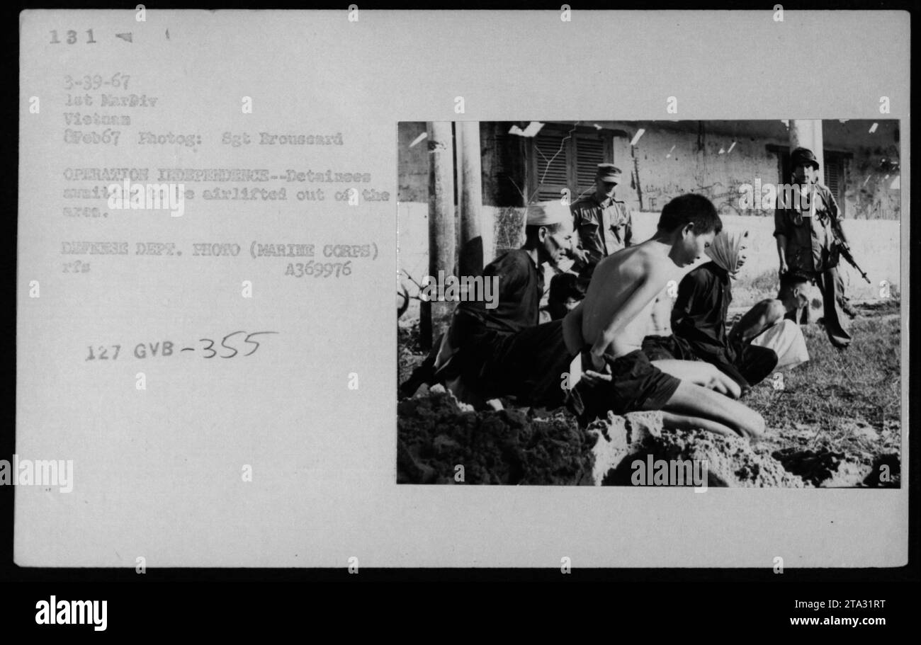 Un groupe de suspects et de prisonniers Viet Cong attendent un pont aérien pour être transporté hors des 6700 dans le cadre de l'opération indépendance le 8 février 1967. Cette photographie capture la situation pendant la guerre du Vietnam. L'image provient de la photo du Département de la Défense, gracieuseté du sergent Broussard. Banque D'Images