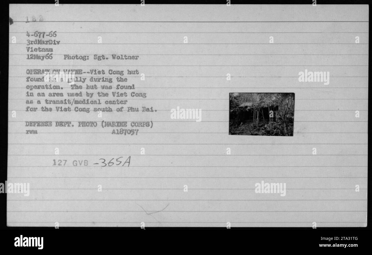 Un Marine américain se tient à côté d'une cabane Viet Cong découverte lors de l'opération Wayne le 12 mai 1966. La cabane était située dans un ravin qui servait de centre de transit et médical pour les Viet Cong dans la région de Phu Bai. Cette photographie est une photo du Département de la Défense prise par le sergent Woltner de la 3e Division des Marines. Banque D'Images