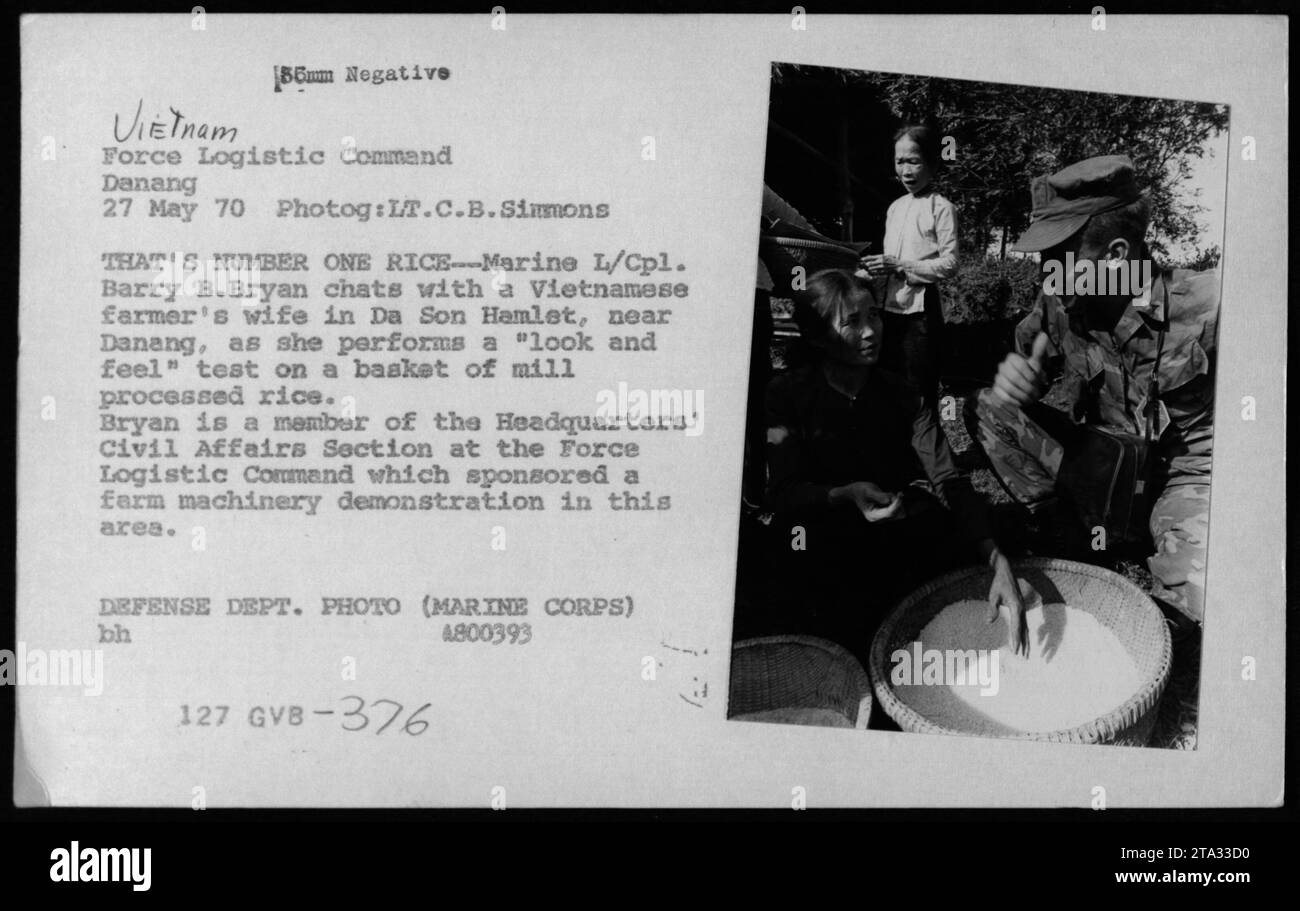 Marine L/capt. Barry B. Bryan parlant à la femme d'un fermier vietnamien à Da son Hamlet, près de Danang, lors d'une démonstration de machines agricoles parrainée par le Commandement logistique de la Force en mai 1970. La femme est vue effectuant un test de «look and feel» sur un panier de riz transformé de moulin. Banque D'Images