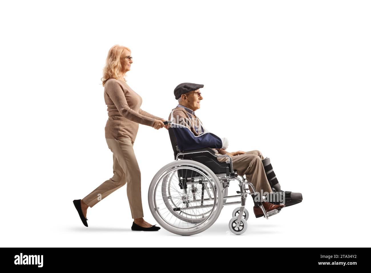 Femme mature poussant un homme âgé blessé dans un fauteuil roulant isolé sur fond blanc Banque D'Images