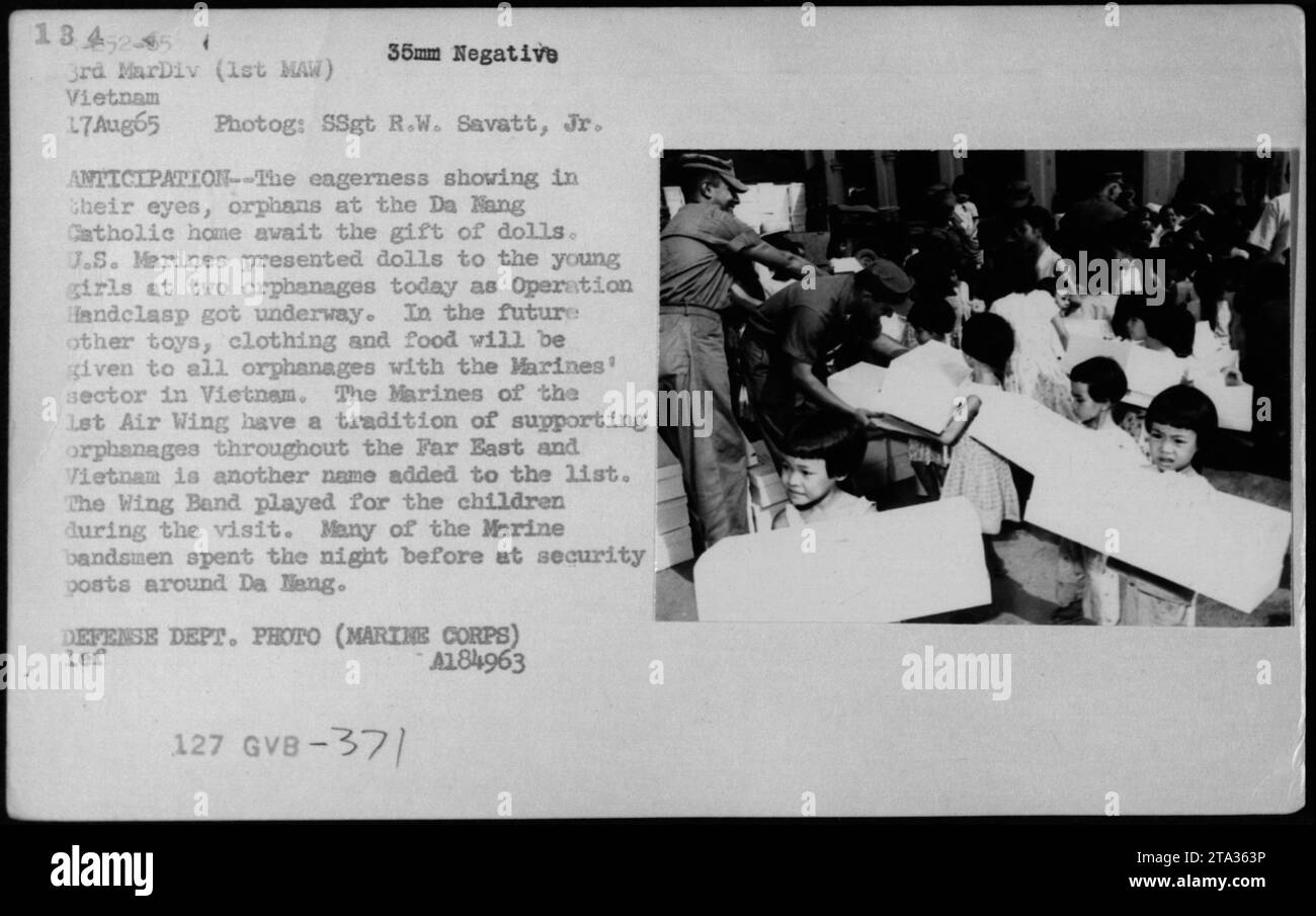 Les Marines AMÉRICAINS de la 1e escadre aérienne participent à l'opération Handclaps en présentant des poupées aux orphelins à la maison catholique Da Nang au Vietnam le 17 août 1965. Cet événement a marqué le début de la distribution de jouets, de vêtements et de nourriture à tous les orphelinats du secteur des Marines. Les Marines ont une longue tradition de soutien aux orphelinats en extrême-Orient, et le Vietnam a fait partie de cet effort. Le Wing Band a également diverti les enfants pendant la visite. Photo du ministère de la Défense (corps des Marines). Banque D'Images