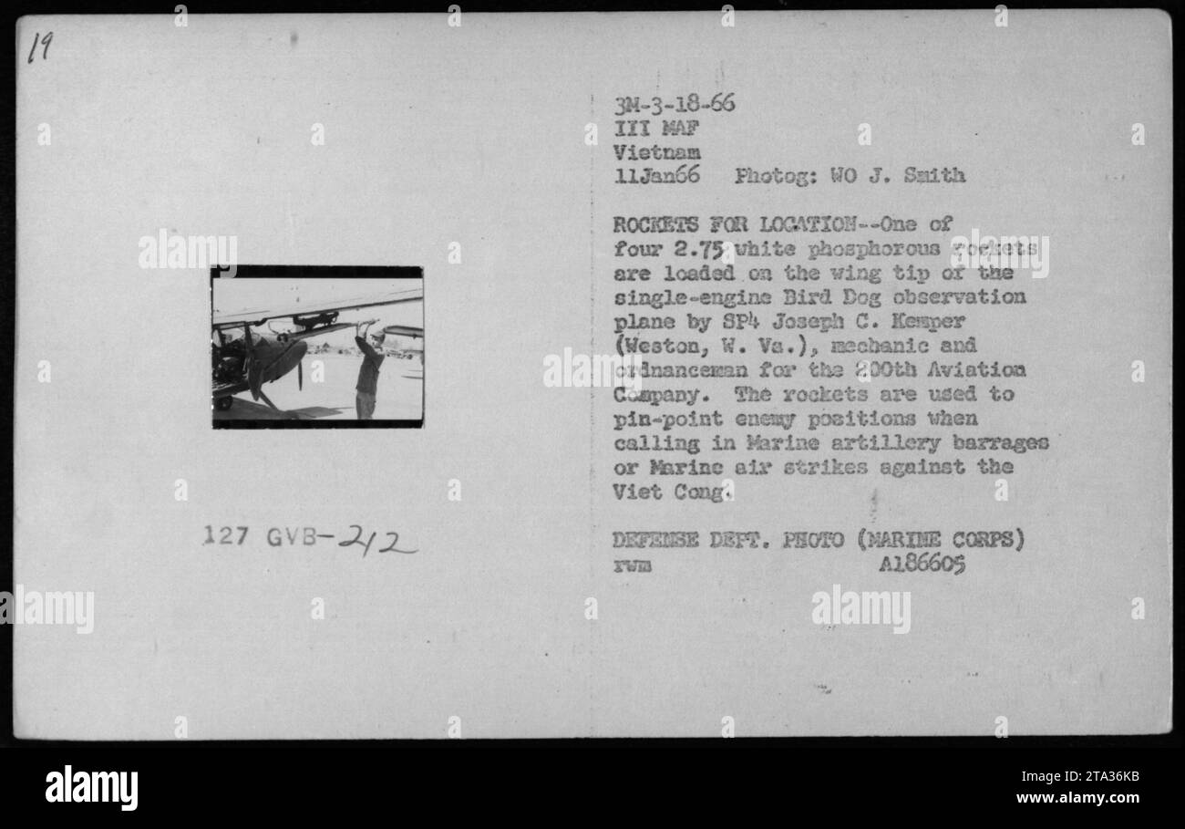 Le SP Joseph C. Kemper charge 2,75 roquettes au phosphore blanc sur l'extrémité d'une aile d'un avion d'observation monomoteur Bird Dog au Vietnam le 11 janvier 1966. Les roquettes ont été utilisées pour localiser les positions Viet Cong lors de la demande de barrages d'artillerie des Marines ou de frappes aériennes contre l'ennemi dans les activités militaires américaines pendant la guerre du Vietnam. Banque D'Images