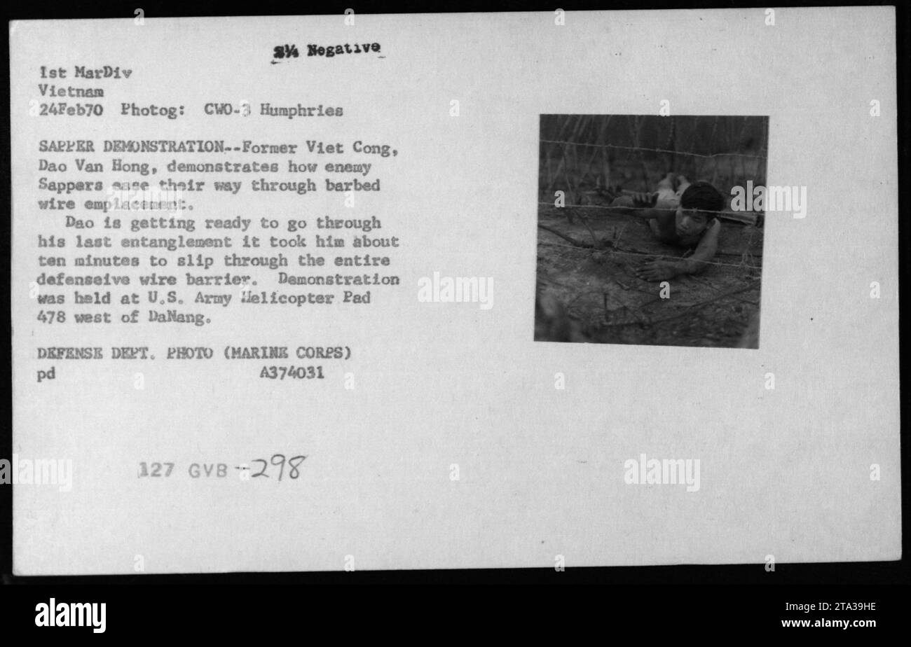 Un membre réformé du Viet Cong, Dao Van Hong, montre comment les sapeurs ennemis naviguent à travers des emplacements de fil barbelé lors d'une démonstration à l'US Army Helicopter Pad 478 à l'ouest de Danang le 24 février 1970. Il a fallu environ dix minutes à Dao pour passer à travers toute la barrière défensive. Banque D'Images