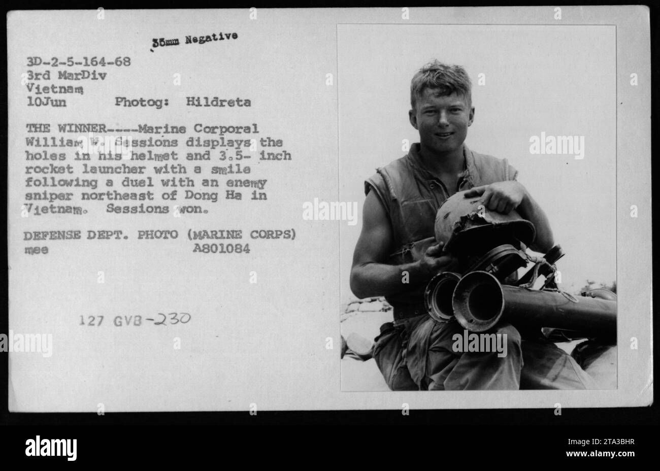 Le caporal William W. sessions montre fièrement les dommages causés à son casque et à son lance-roquettes après une confrontation réussie avec un sniper ennemi près de Dong Ha au Vietnam. Cette photographie capture des séances souriantes, illustrant sa victoire et sa résilience face au danger. Prise le 3 juin 1968 par la photographe Hildreta, elle dépeint la détermination et la bravoure manifestées par les militaires américains pendant la guerre du Vietnam. Banque D'Images