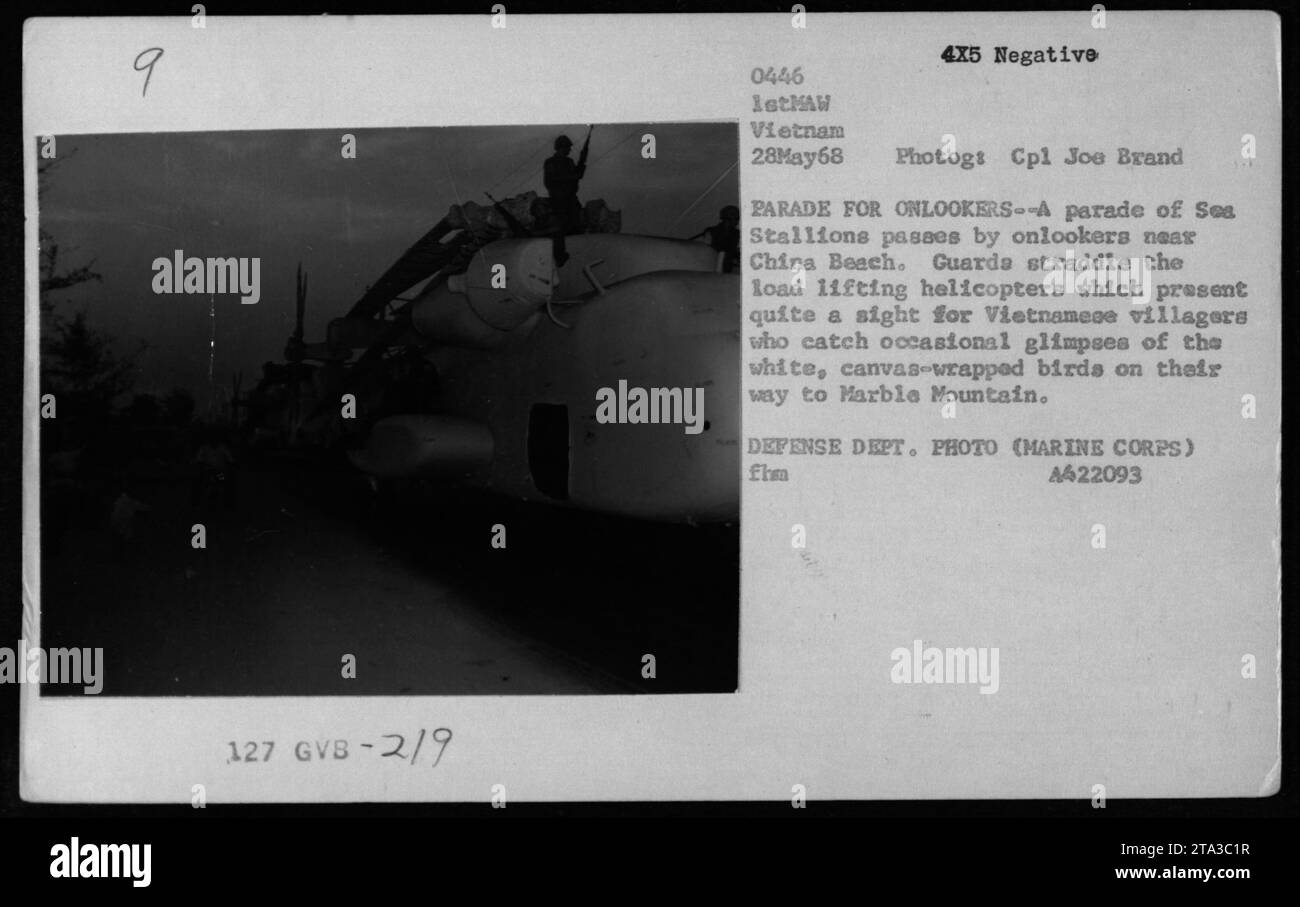 Des hélicoptères militaires du modèle CH-53 sont vus sur cette photographie prise le 28 mai 1968 pendant la guerre du Vietnam. Les hélicoptères, appelés « ses Stallions », participent à un défilé près de China Beach. Les villageois vietnamiens observent l'avion, enveloppé dans une toile blanche, alors qu'ils volent vers Marble Mountain. Photographie prise par le Cpl Joe Brand. Cette image est une photo du Département de la Défense par le corps des Marines (A422093). Banque D'Images