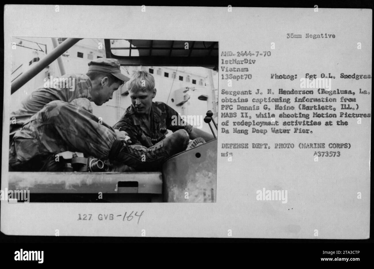 Le sergent J. N. Henderson, un photographe de combat de Bogalusa, Louisiane, s'entretient avec le soldat Dennis G. Heine lors d'un tournage à Da Nang Deep Water Pier. La photographie capture la scène alors que Henderson recueille des informations de sous-titrage tout en filmant les activités de redéploiement de la 1e Division des Marines au Vietnam. » Banque D'Images