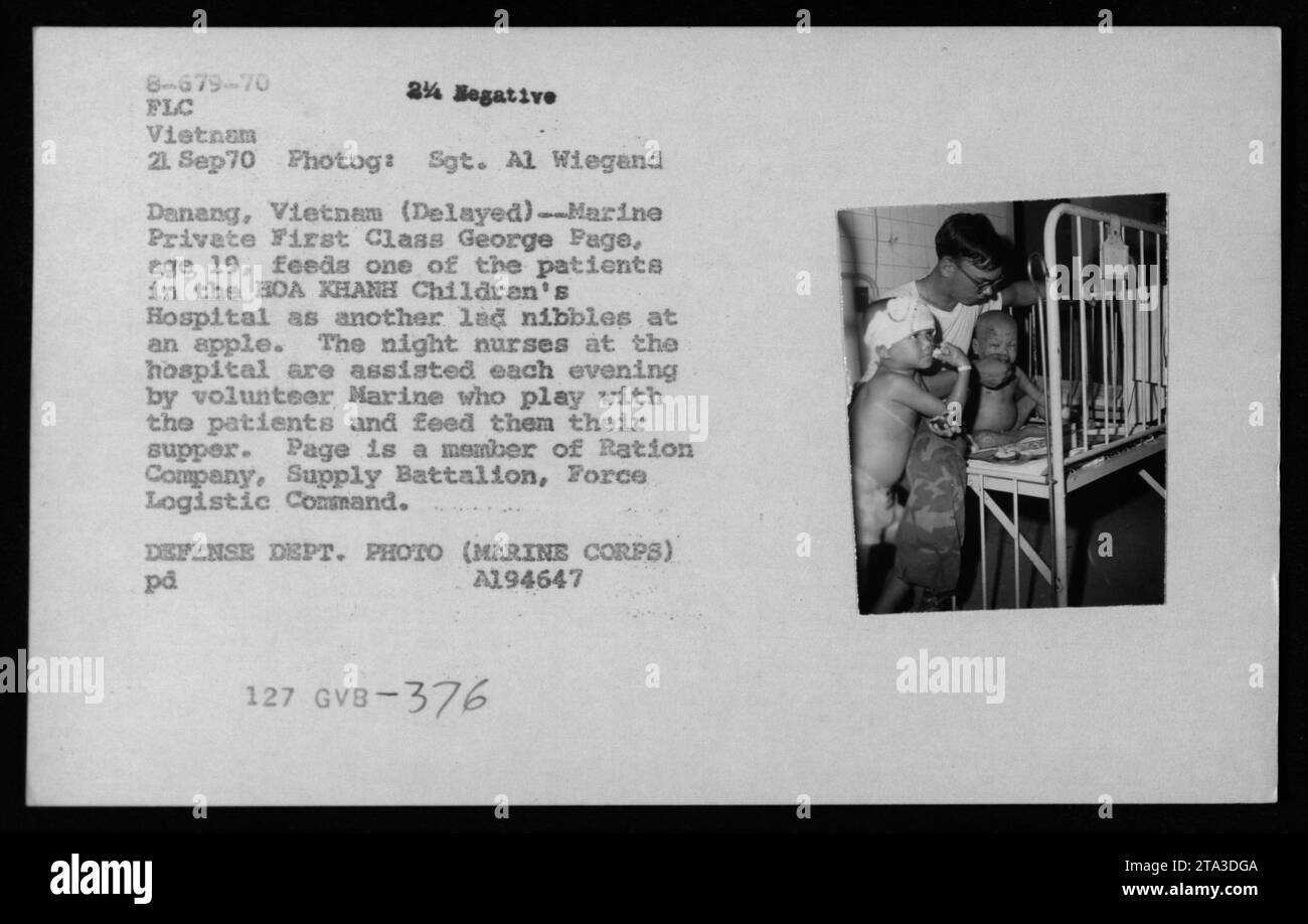 Soldat marin de première classe George page, 19 ans, bénévole à l'hôpital pour enfants HOA KHANH à Danang, Vietnam. Il est vu nourrir un des patients tandis qu'un autre enfant mange une pomme. Page, membre de la compagnie de ration, Bataillon d'approvisionnement, Force Logistic Command, aide les infirmières de nuit en jouant avec les patients et en aidant à leur souper. La photo a été prise le 21 septembre 1970 par le sergent Al Wiegand et fait partie de la collection documentant les activités militaires américaines pendant la guerre du Vietnam. Banque D'Images