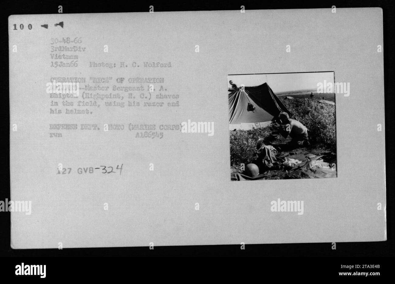 Le sergent-chef R. A. Shipton se rase sur le terrain en utilisant son casque comme miroir pendant l'opération Rice, qui fait partie de l'opération Hallard, le 15 janvier 1966, documentant l'hygiène du terrain pendant les activités militaires de la guerre du Vietnam. Banque D'Images