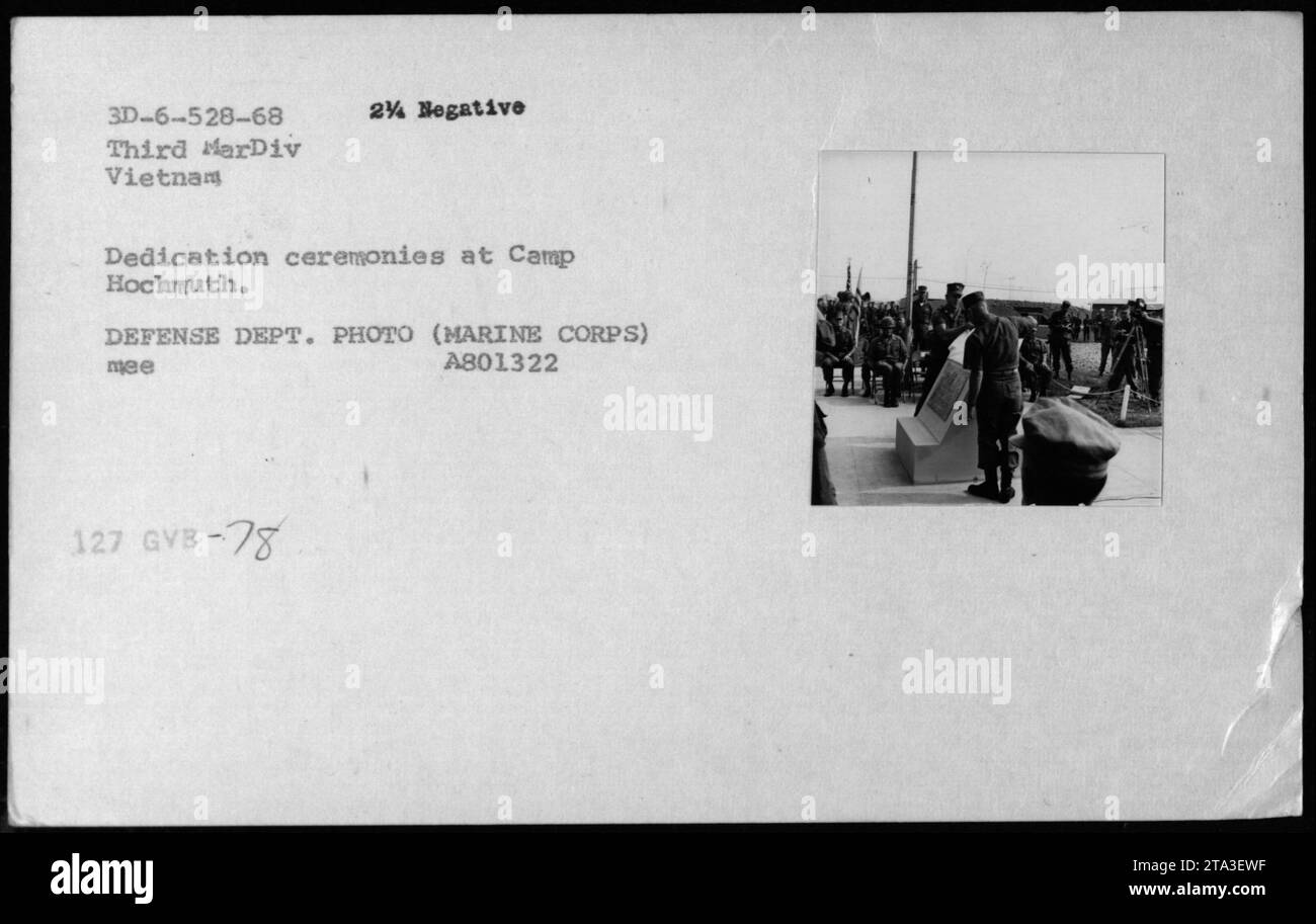 Cérémonies de dédicace au Camp Hochmuth, Vietnam, tenues en 1968 par la troisième MarDiv. L'image montre le personnel militaire et les officiels réunis en formation devant un podium. Il y a un podium avec des microphones installés pour les orateurs. L'atmosphère est formelle et officielle, avec drapeaux et bannières présents. Banque D'Images