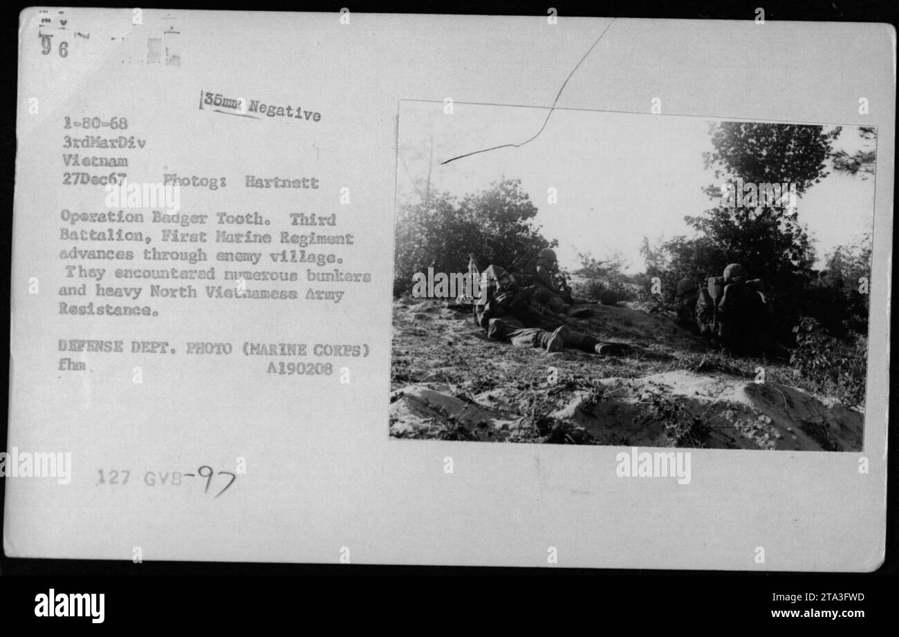 Les Marines du troisième bataillon du premier régiment de Marines avancent à travers un village ennemi pendant l'opération Badger Tooth. Ils font face à la résistance de plusieurs bunkers de l'armée nord-vietnamienne et rencontrent une forte opposition. Cette photographie a été prise le 27 décembre 1967 au Vietnam par le photographe Hartnett. Banque D'Images