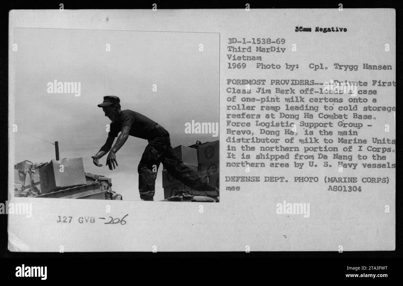 Le soldat de première classe Jim Bark décharge une caisse de cartons de lait d'une pinte à la base de combat de Dong Ha au Vietnam. Dong Ha est le principal distributeur de lait aux unités marines dans la partie nord du Ier corps. Le lait est transporté de Da Nang à la zone nord par des navires de la marine américaine. Photo prise en 1969 par le caporal Trygg Hansen. Banque D'Images