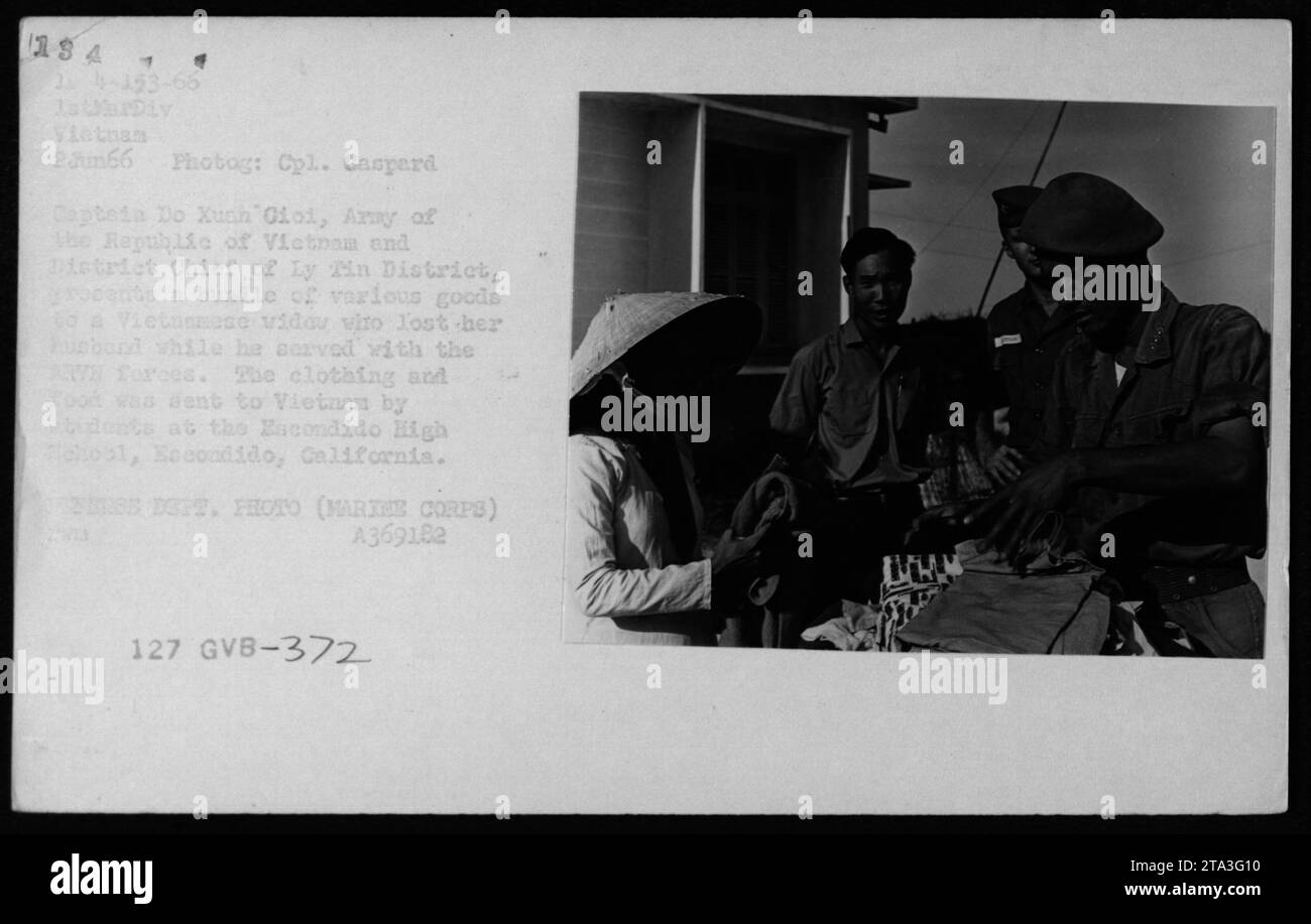 Le caporal Caspard Captein et le chef de district Do Xuan Gioi présentent des vêtements et de la nourriture donnés par l’école secondaire Escondido à une veuve vietnamienne du district de Ly min, au Vietnam, le 2 juin 1966. Banque D'Images