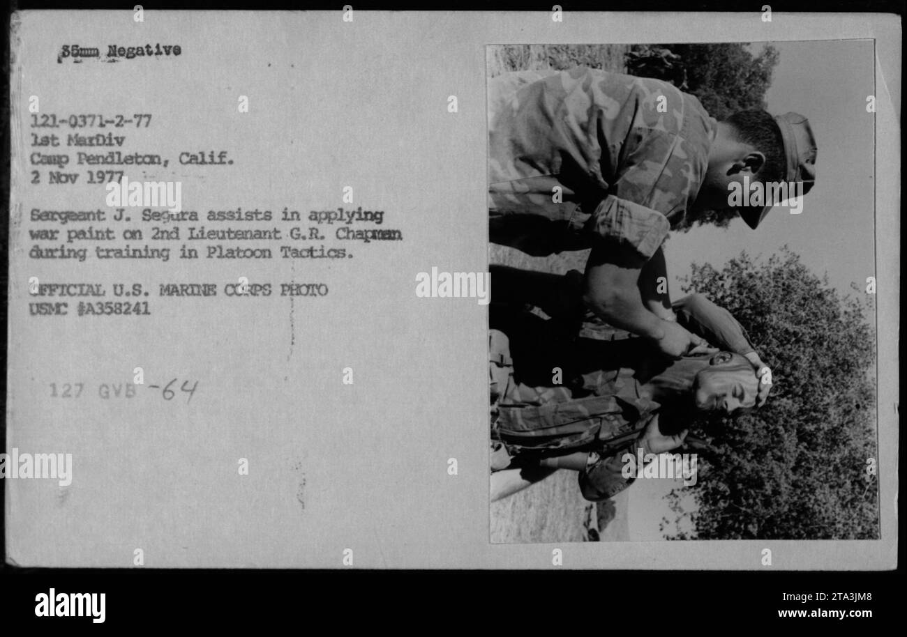 Le sergent J. Segura aide le 2nd Lieutenant G.R. Chapman à appliquer de la peinture de camouflage lors de l'entraînement des tactiques de peloton au Camp Pendleton, en Californie. La photo, prise le 2 novembre 1977, capture une activité officielle du corps des Marines des États-Unis. Cette image montre la préparation et le souci du détail requis dans les opérations militaires pendant la guerre du Vietnam. Banque D'Images