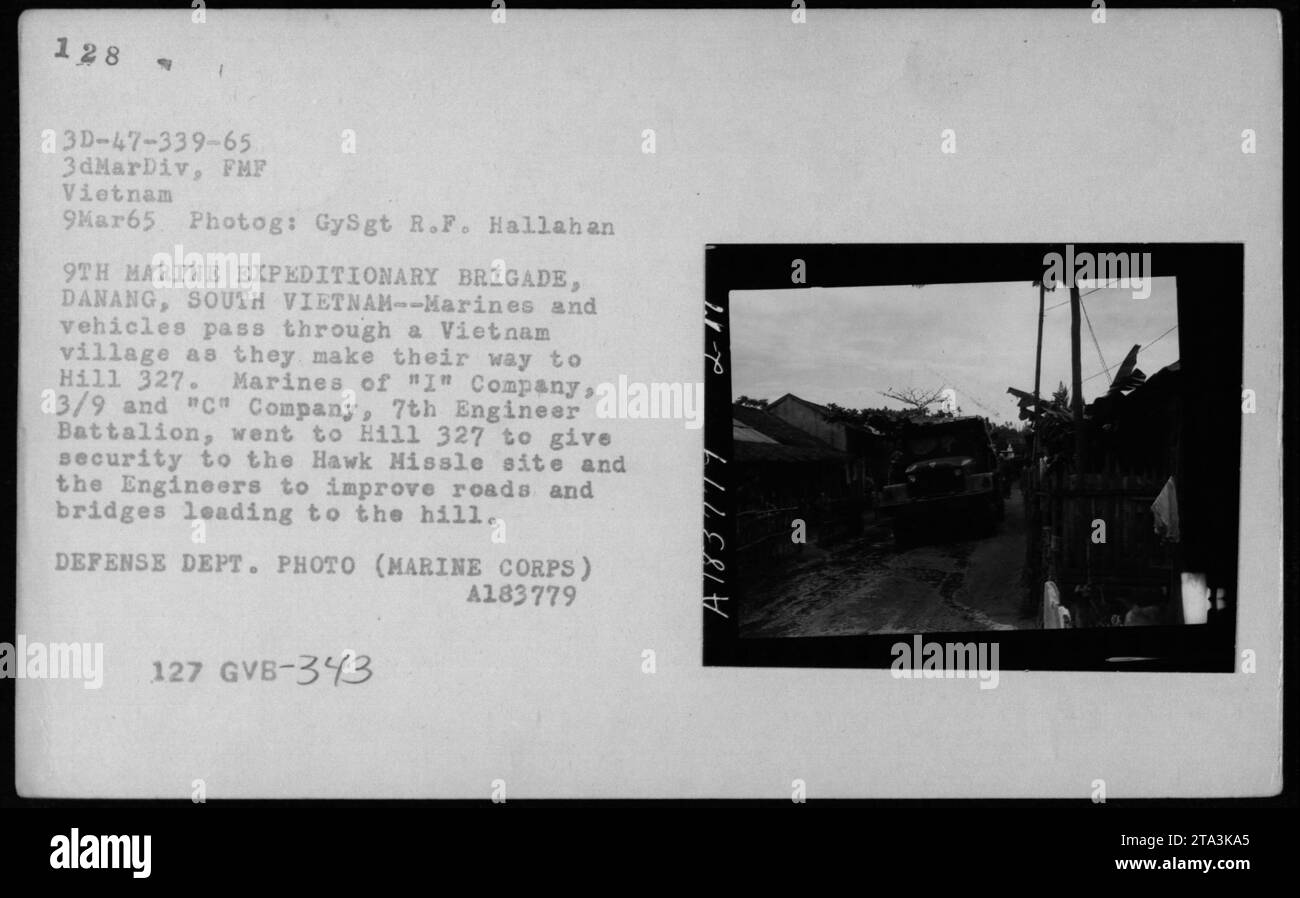 Les Marines et les véhicules traversent un village du Vietnam le 9 mars 1965, alors qu'ils se rendent à la colline 327. Les Marines de la compagnie 'I', 3/9 et de la compagnie 'C', 7e bataillon du génie, se rendent sur la colline 327 pour assurer la sécurité du site Hawk Hissle et améliorer les routes et les ponts menant à la colline. Cette photographie fait partie des activités militaires américaines pendant la guerre du Vietnam. Banque D'Images