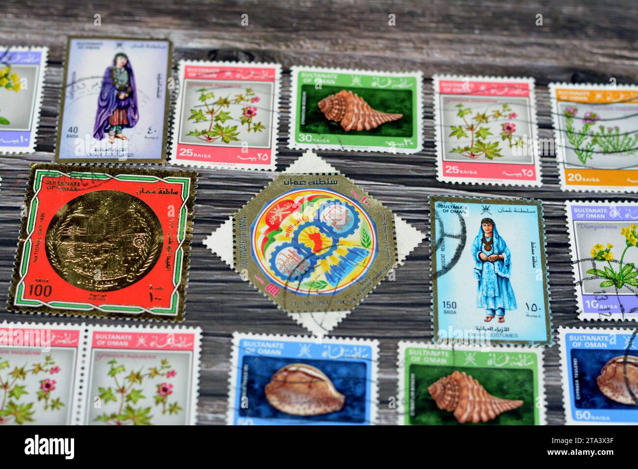 Le Caire, Égypte septembre 21 2022 : le sultanat omanais ancien a utilisé des timbres-poste à différentes époques sur un fond en bois, une couverture avec une série de timbres-poste Banque D'Images