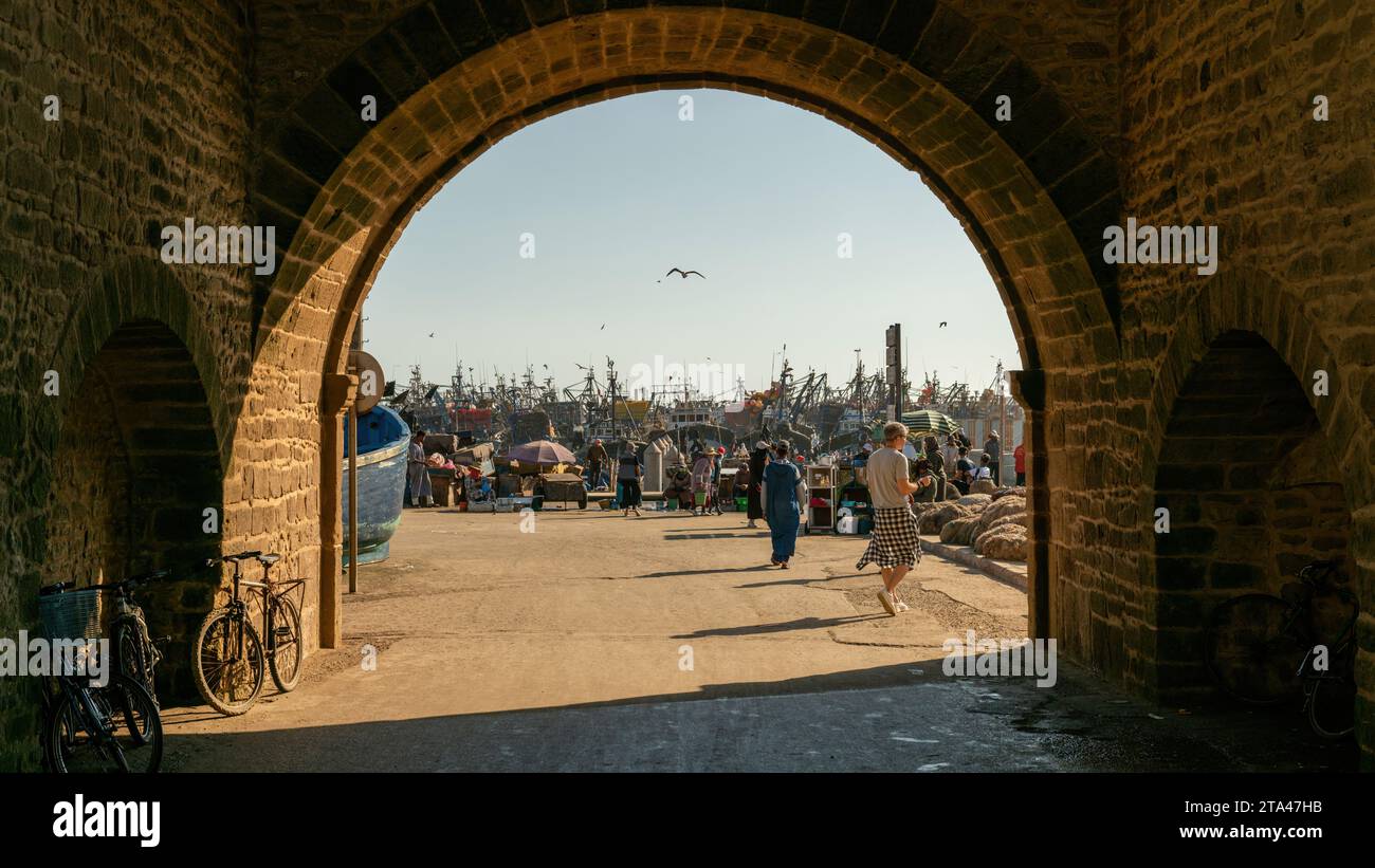 Essaouira, Maroc - 16 septembre 2022 : Port d'Essaouira avec touristes et bateaux de pêcheurs. Les bateaux de pêche bordent le port, apportant le catc de la journée Banque D'Images