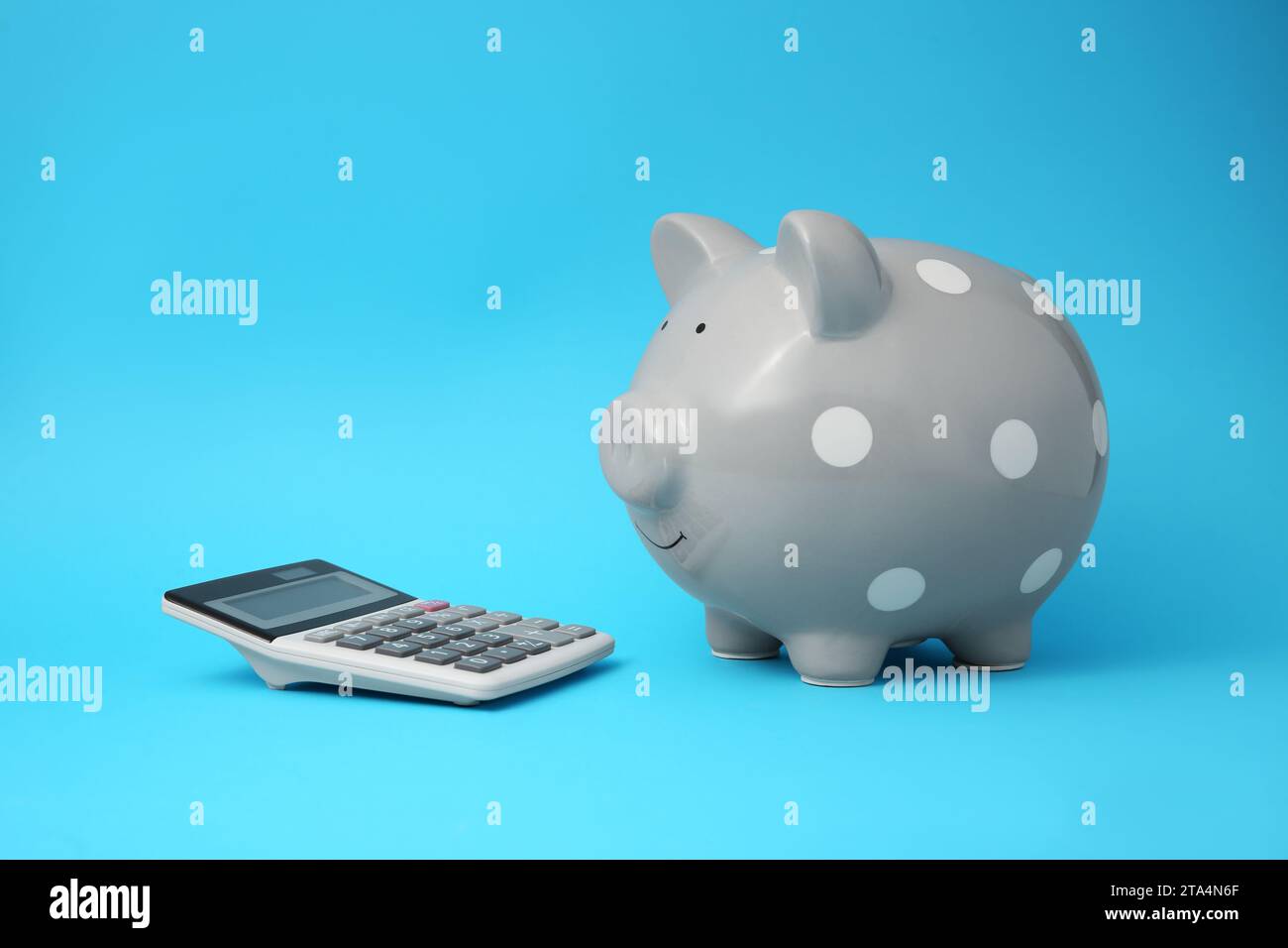 Tirelire et calculatrice sur fond bleu clair Banque D'Images