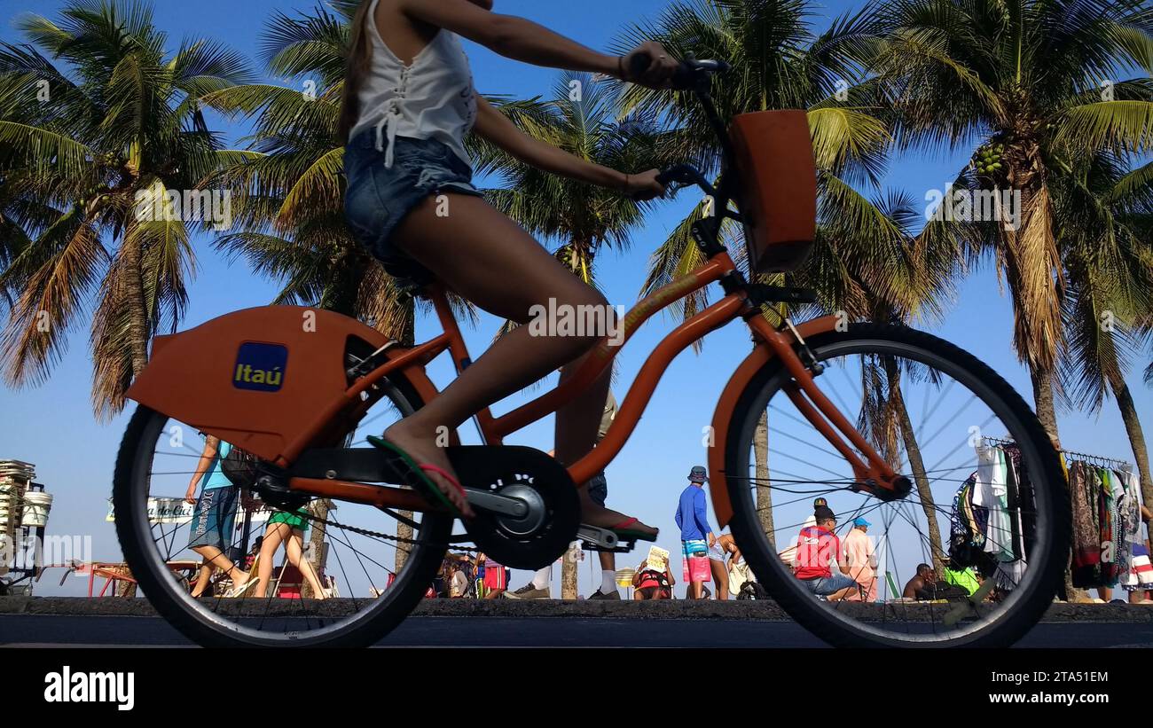 Les cyclistes se déplacent sur la piste cyclable située à côté de la promenade de la plage de Copacabana en utilisant le système local de partage de vélos (Bike Itau), un service de transport partagé où des vélos sont disponibles pour une utilisation partagée par les particuliers à faible coût. Rio de Janeiro, Brésil. Banque D'Images