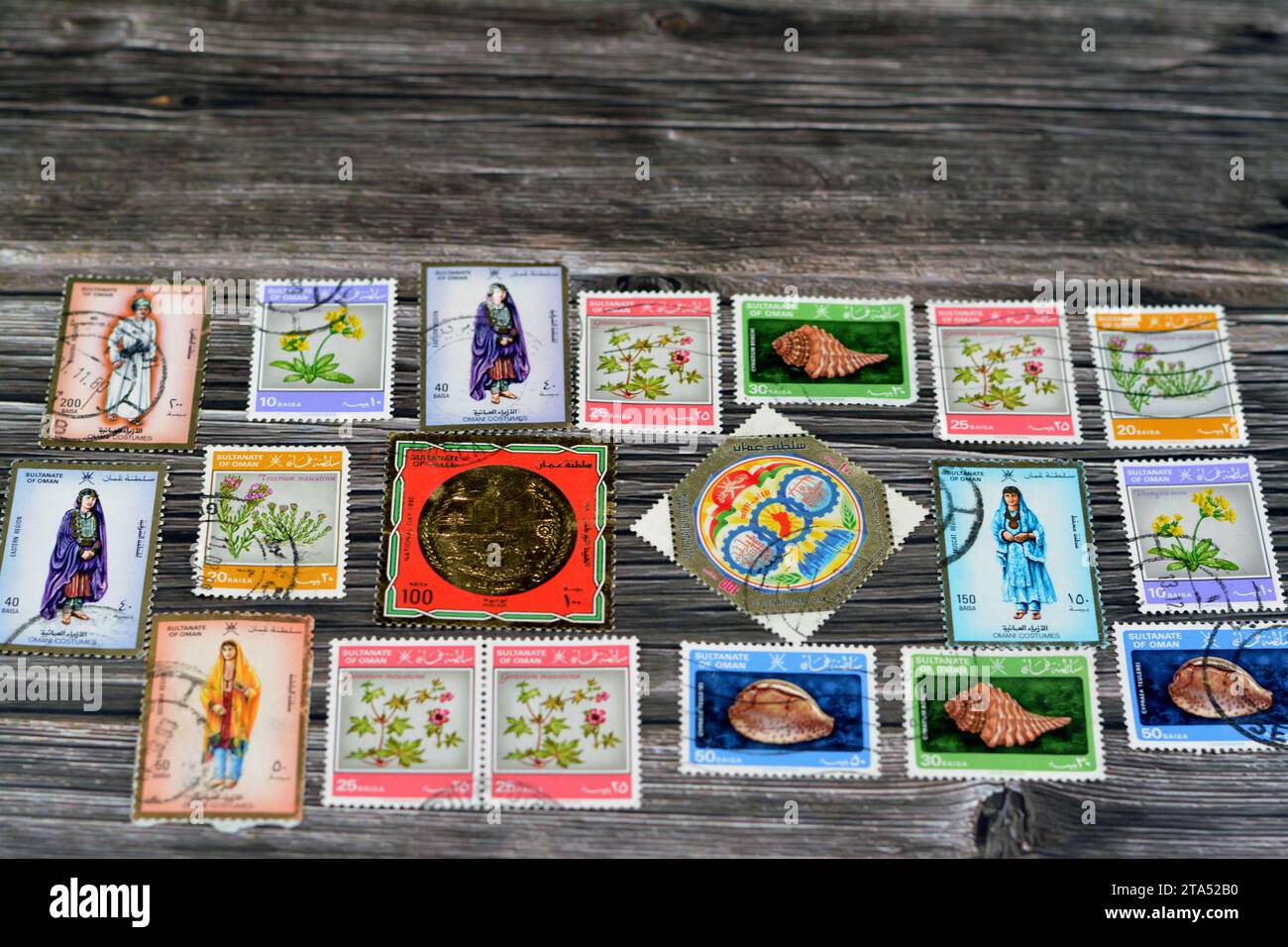 Le Caire, Égypte septembre 21 2022 : le sultanat omanais ancien a utilisé des timbres-poste à différentes époques sur un fond en bois, une couverture avec une série de timbres-poste Banque D'Images