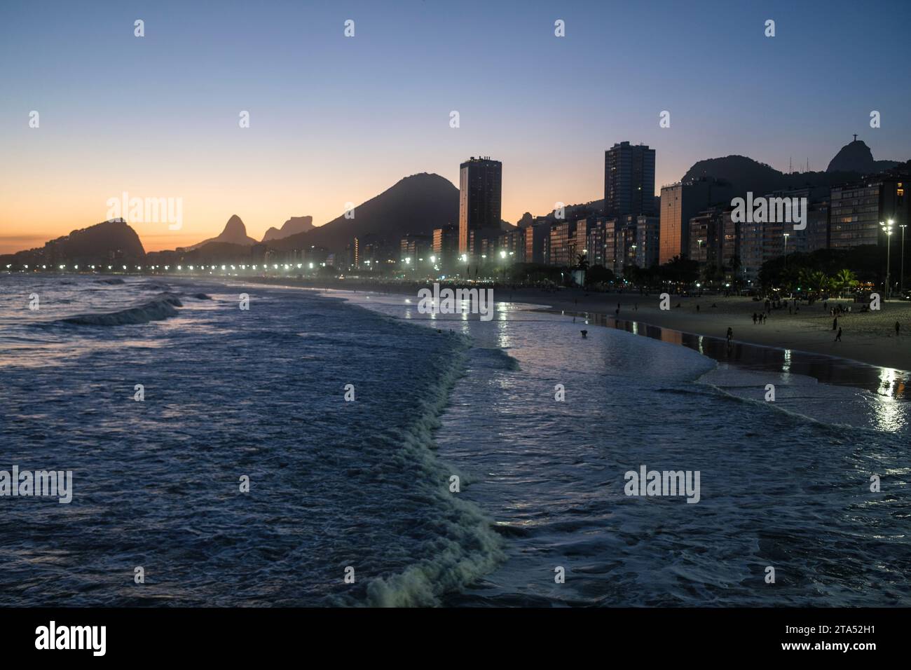 Leme et la plage de Copacabana au coucher du soleil, Rio de Janeiro, Brésil. Christ Rédempteur juste derrière les bâtiments du front de mer. Morro dois Irmãos et Pedra da Gávea à gauche en arrière-plan. Banque D'Images