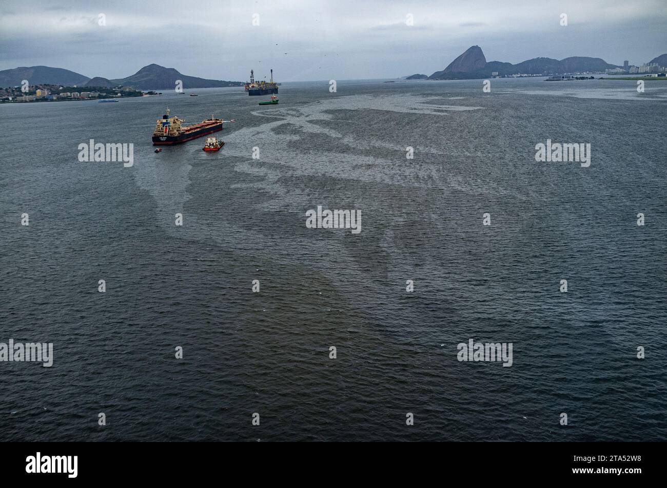 Vue aérienne du trafic maritime intense dans la baie de Guanabara, Rio de Janeiro, Brésil, où pétroliers, navires de charge, et les navires de soutien dominent les eaux. La baie, plaque tournante vitale pour le transport maritime et la logistique pétrolière, est confrontée à des défis environnementaux continus en raison de l’étalement urbain, des eaux usées non traitées, des déchets solides et des déversements récurrents d’hydrocarbures, qui menacent tous ses écosystèmes marins et la qualité de l’eau. Banque D'Images Vue aérienne du trafic maritime intense dans la baie de Guanabara, Rio de Janeiro, Brésil, où pétroliers, navires de charge, et les navires de soutien dominent les eaux. La baie, plaque tournante vitale pour le transport maritime et la logistique pétrolière, est confrontée à des défis environnementaux continus en raison de l’étalement urbain, des eaux usées non traitées, des déchets solides et des déversements récurrents d’hydrocarbures, qui menacent tous ses écosystèmes marins et la qualité de l’eau. Banque D'Images