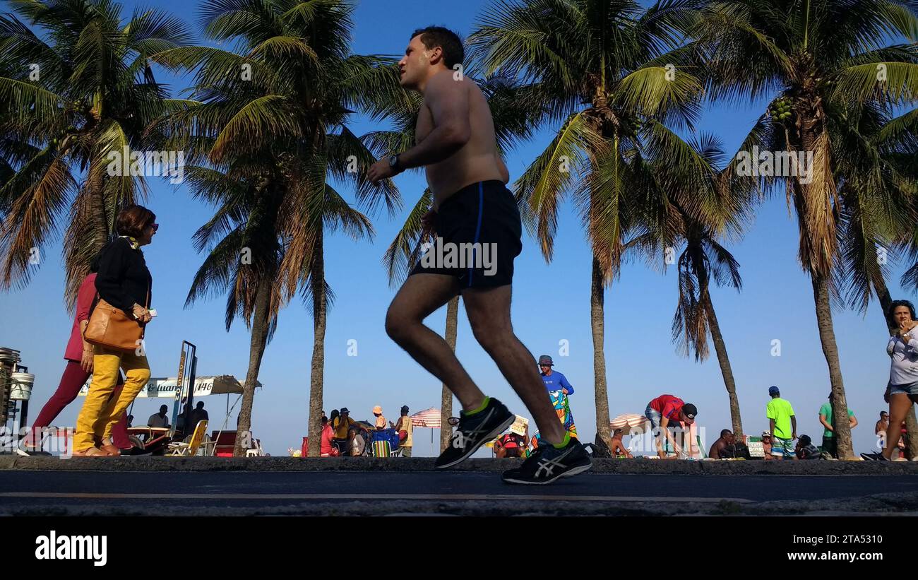 Coureur sur la piste cyclable située à côté de la promenade de la plage de Copacabana, Rio de Janeiro, Brésil. Banque D'Images