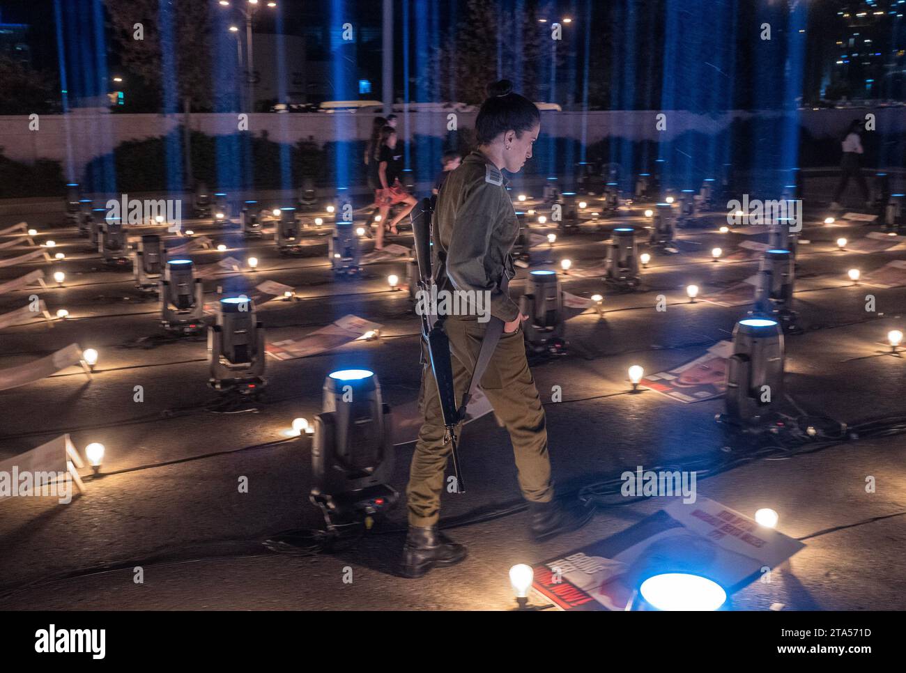 Jérusalem, Israël. 29 octobre 2023. Une soldat israélienne armée regarde les affiches de quelques-uns des 229 Israéliens retenus en otage par le Hamas à l’intérieur de la bande de Gaza lors d’une veillée nocturne tenue à l’extérieur d’un stade sportif au sud de Jérusalem le 29 octobre 2023. La veillée a des portraits de tous les otages disposés sur une terrasse et sera illuminée chaque nuit jusqu'à ce que les otages pris le 7 octobre 2023 lors de l'attaque terroriste du Hamas soient libérés. Photo de Jim Hollander/UPI crédit : UPI/Alamy Live News Banque D'Images