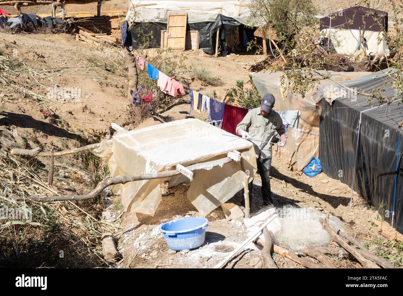 Reconstruction à Amskerajane, montagnes de l'Atlas, Maroc. Homme fabriquant des panneaux de plâtre pour une utilisation dans un abri de transition Banque D'Images