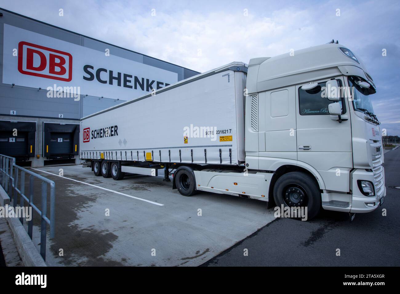 Rostock, Allemagne. 21 novembre 2023. Un camion est stationné devant le bâtiment abritant le nouvel entrepôt à baies hautes de la société de logistique DB Schenker. La filiale logistique de Deutsche Bahn exploite plusieurs centres logistiques dans le Mecklembourg-Poméranie occidentale. Crédit : Jens Büttner/dpa/Alamy Live News Banque D'Images