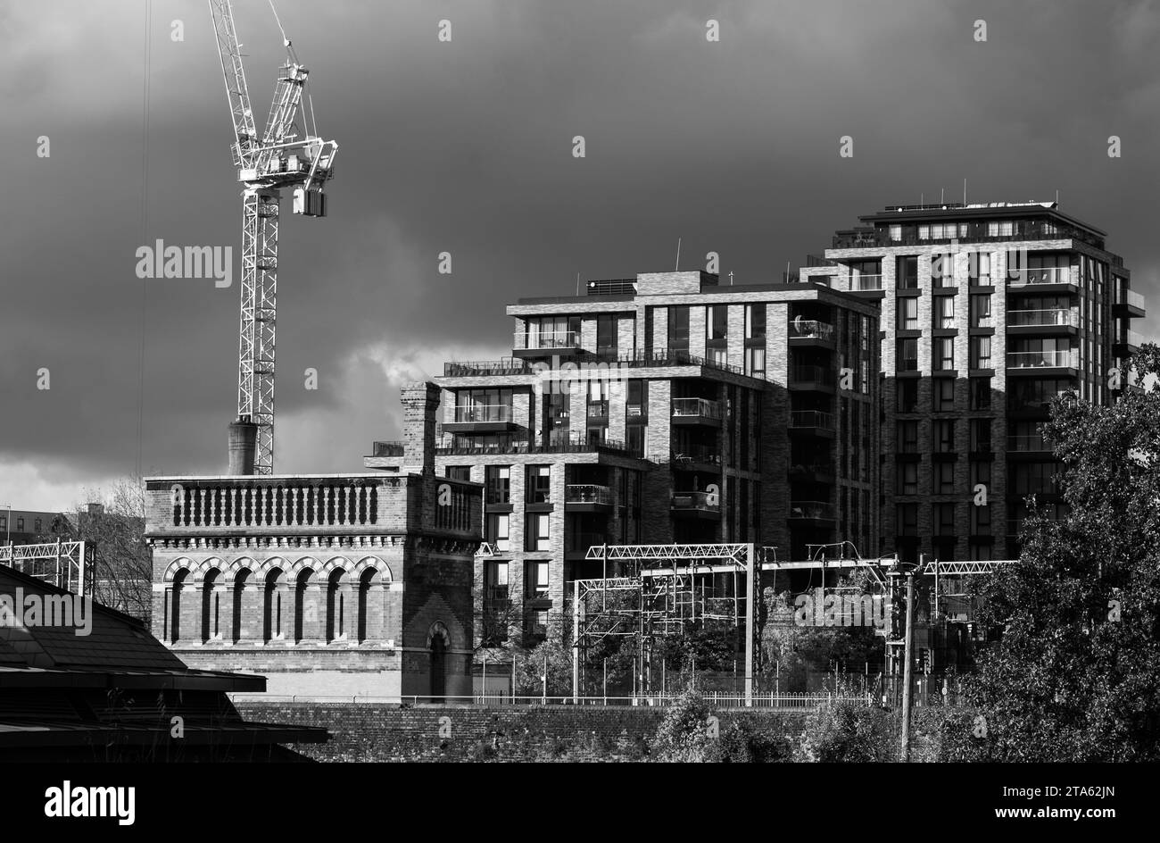 Régénération urbaine de Londres Royaume-Uni. Regent's Canal à Kings Cross, avec de nouveaux immeubles d'appartements et un château d'eau victorien en brique rouge historique à gauche. Banque D'Images