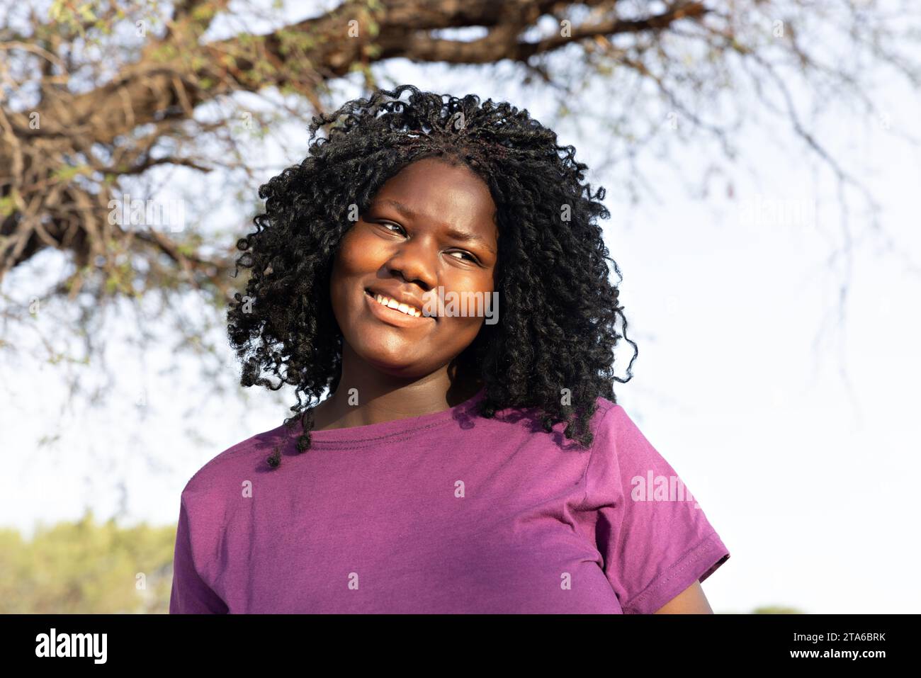 village jeune femme africaine avec des tresses au coucher du soleil Banque D'Images