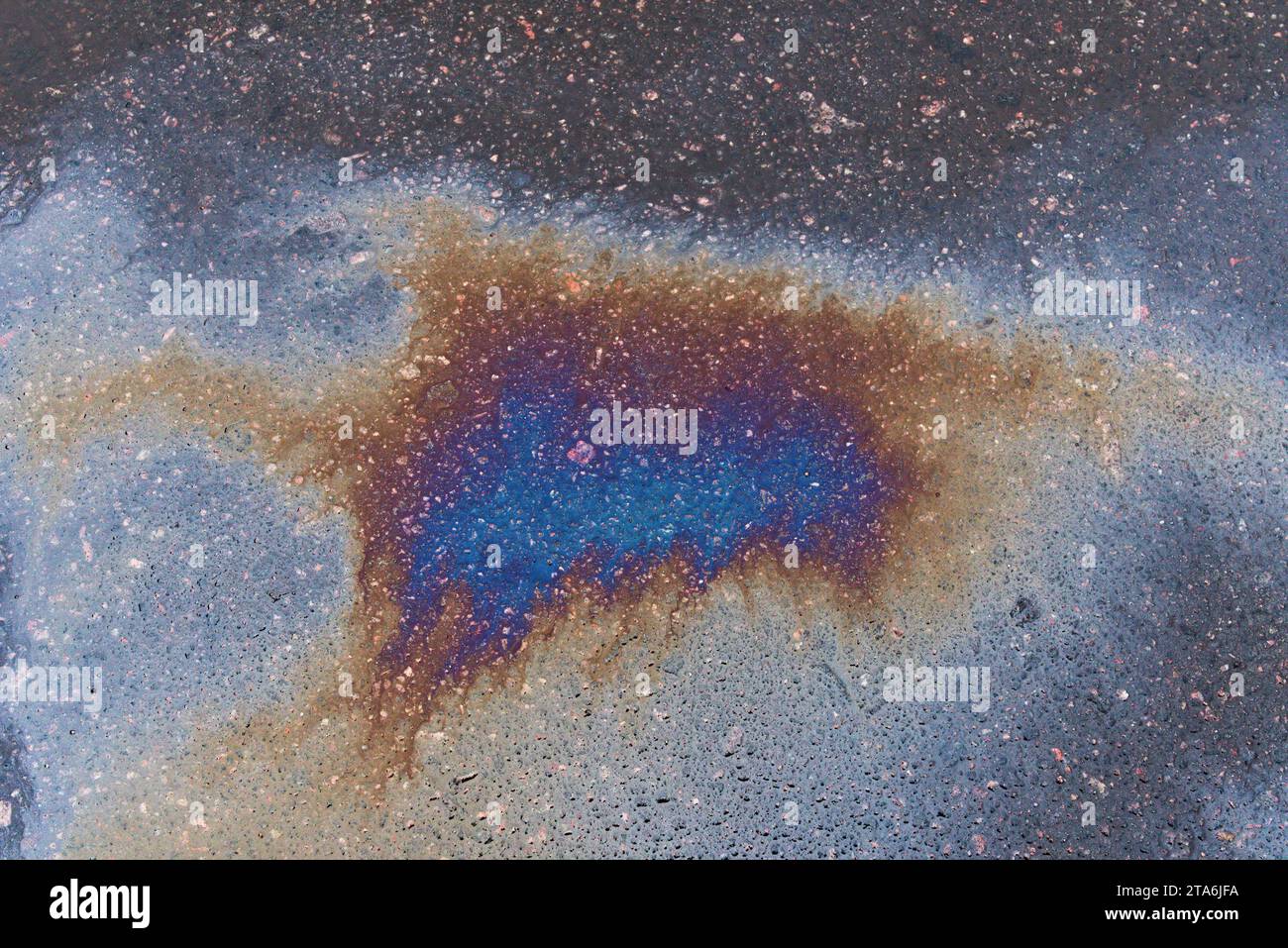 Tache texturée de carburant ou d'huile sur l'asphalte humide un jour de pluie Banque D'Images