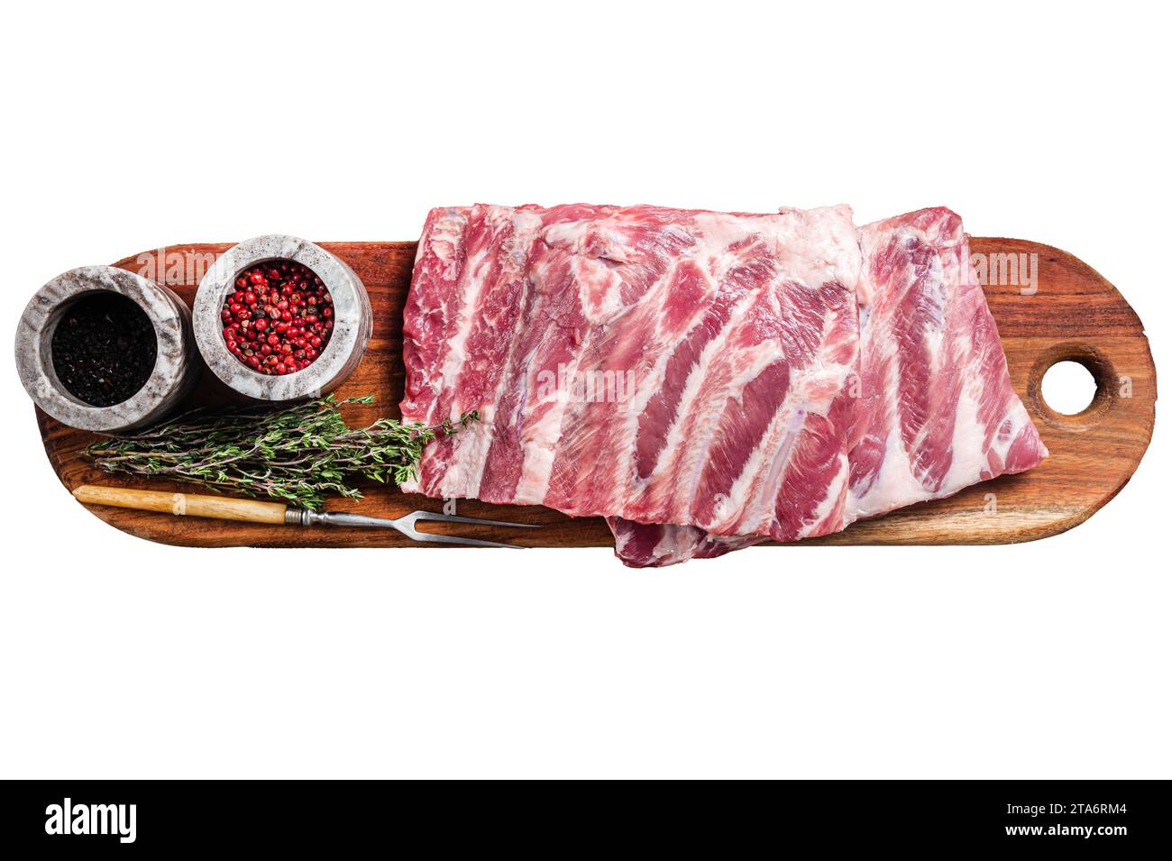 Côtes de porc crues de rechange St Louis sur planche de bois avec des herbes. Isolé, fond blanc Banque D'Images