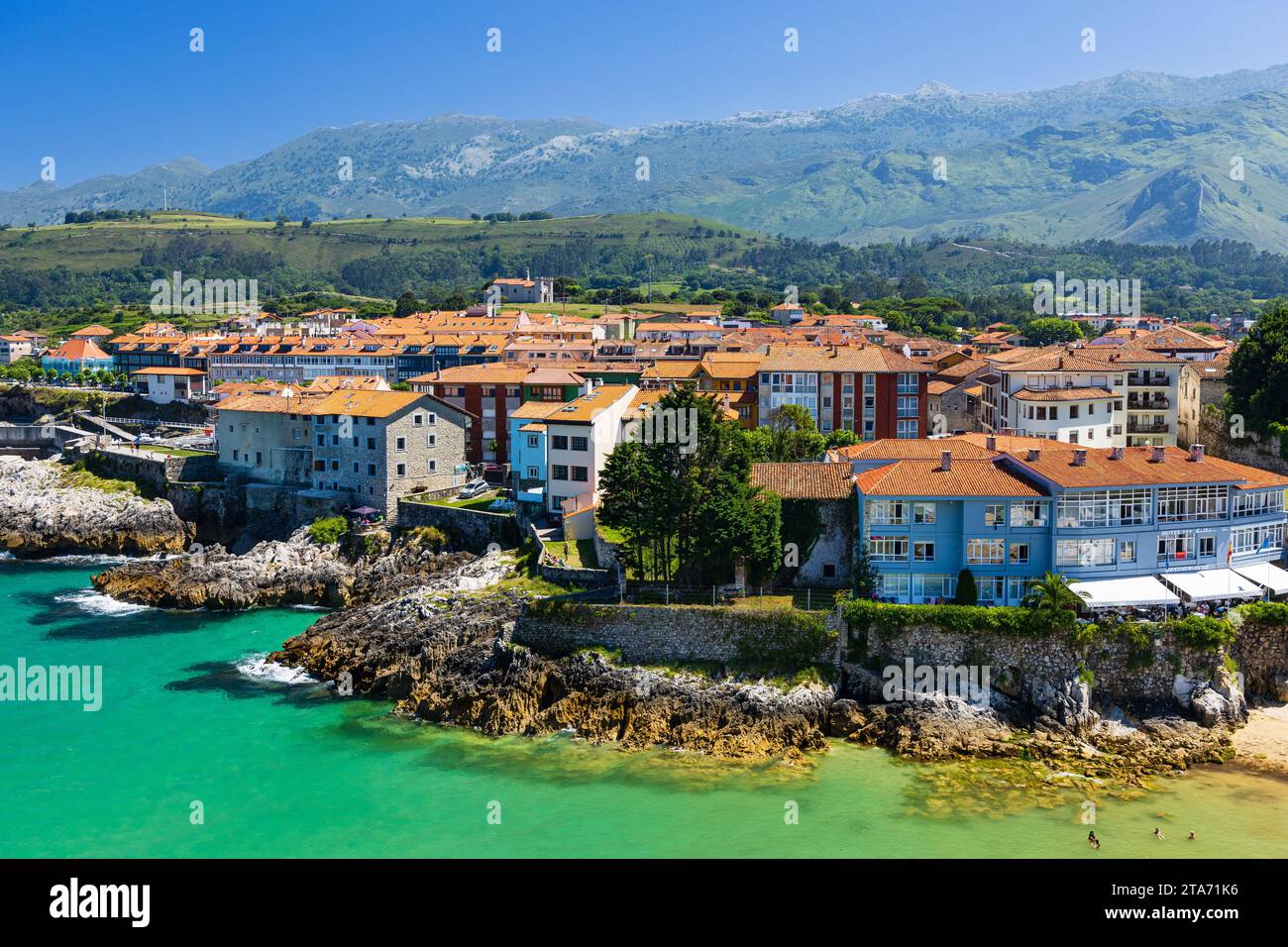 Vue sur la ville de Llanes, falaises, eaux azur de l'océan Atlantique, plage, baignade des gens, montagnes Picos de Europa. Llanes, Asturies, Espagne Banque D'Images