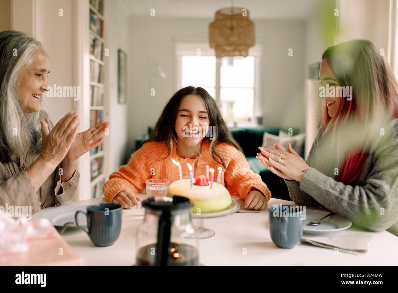 Fille heureuse appréciant et célébrant son anniversaire avec sa famille à la maison Banque D'Images
