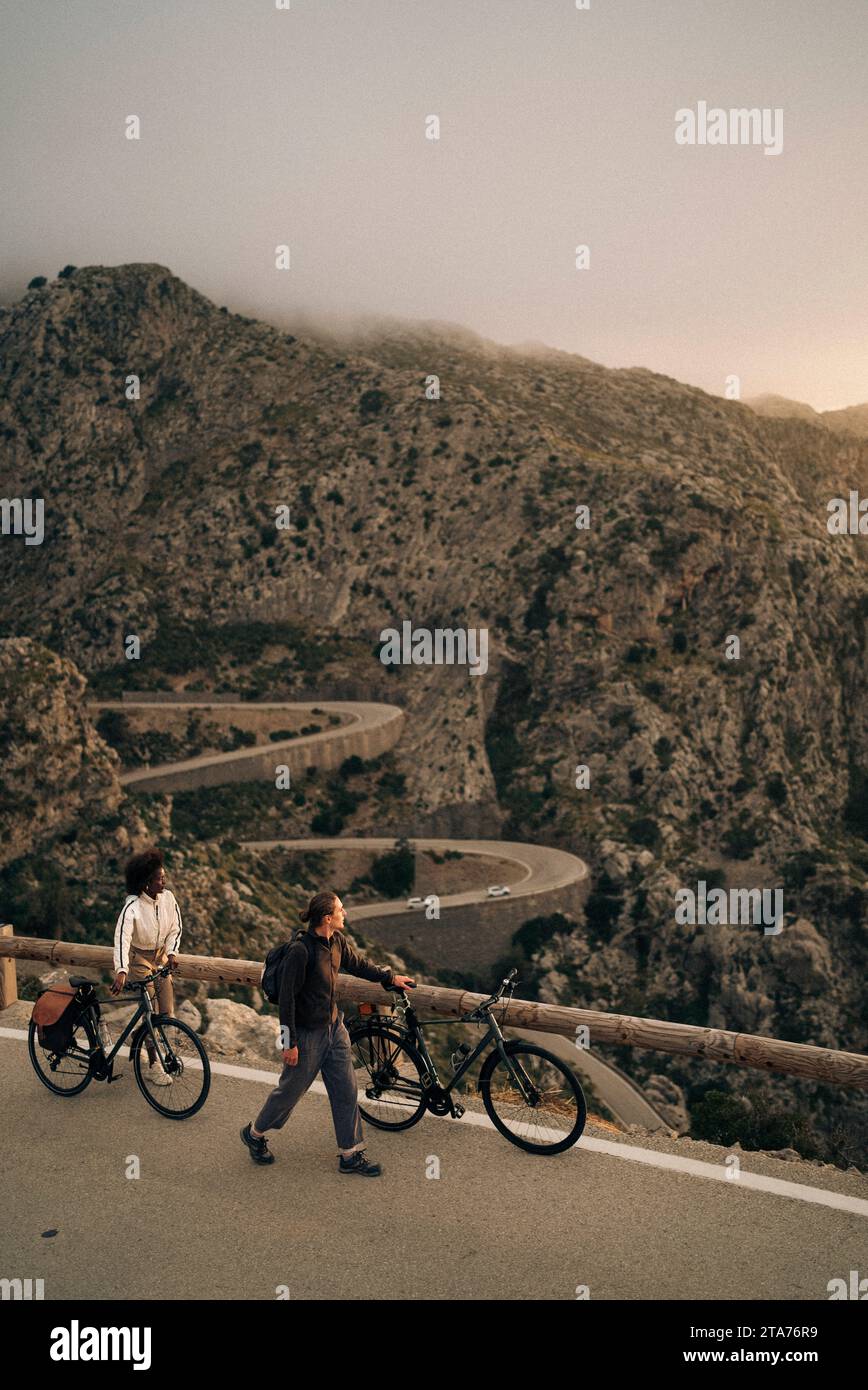 Amis masculins et féminins roulant à vélo et explorant la nature en vacances Banque D'Images