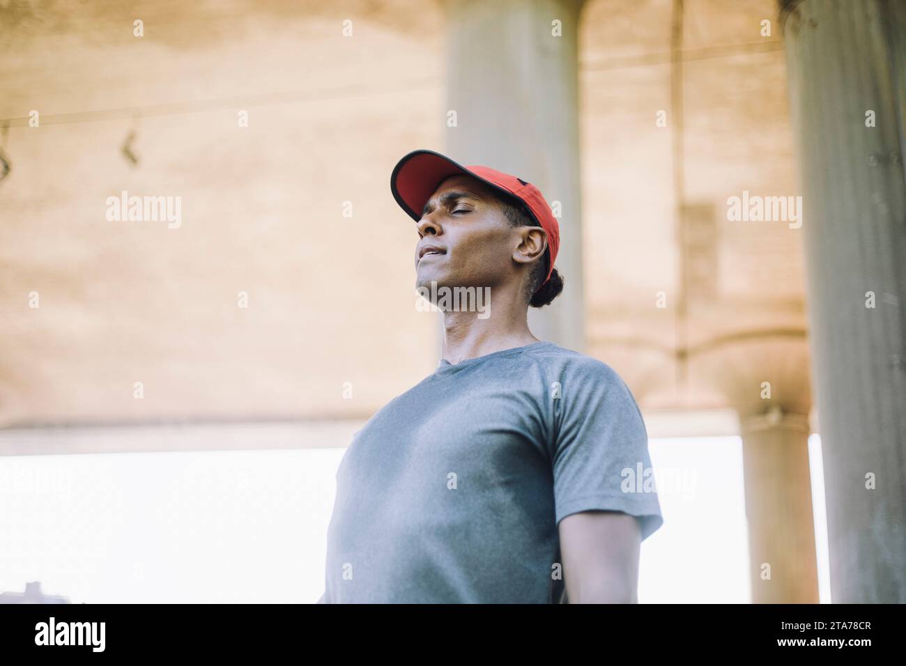 Homme en tenue active s'exerçant avec les yeux fermés Banque D'Images