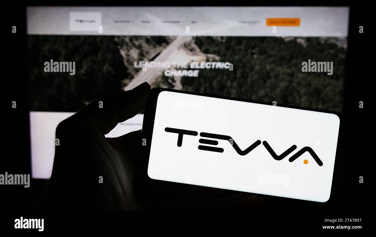 Personne tenant le smartphone avec le logo de la société britannique de camions électriques Tevva Motors Limited en face du site Web. Concentrez-vous sur l'affichage du téléphone. Banque D'Images