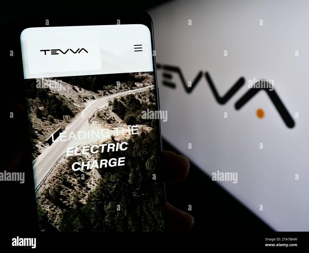 Personne tenant un téléphone portable avec la page Web de la société britannique de camions électriques Tevva Motors Limited devant le logo. Concentrez-vous sur le centre de l'écran du téléphone. Banque D'Images