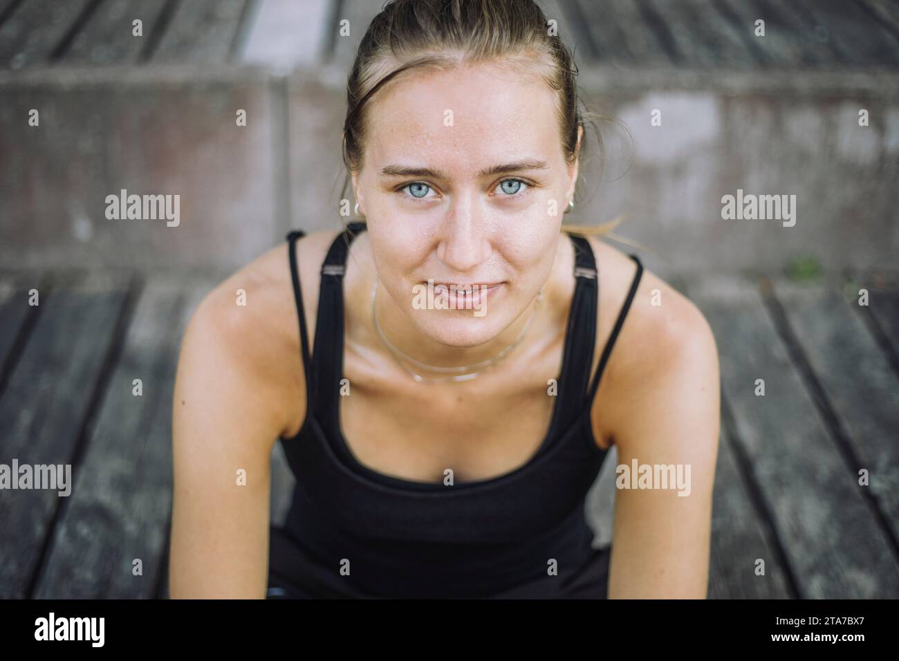 Portrait de jeune femme souriante avec les yeux gris assis sur les marches Banque D'Images