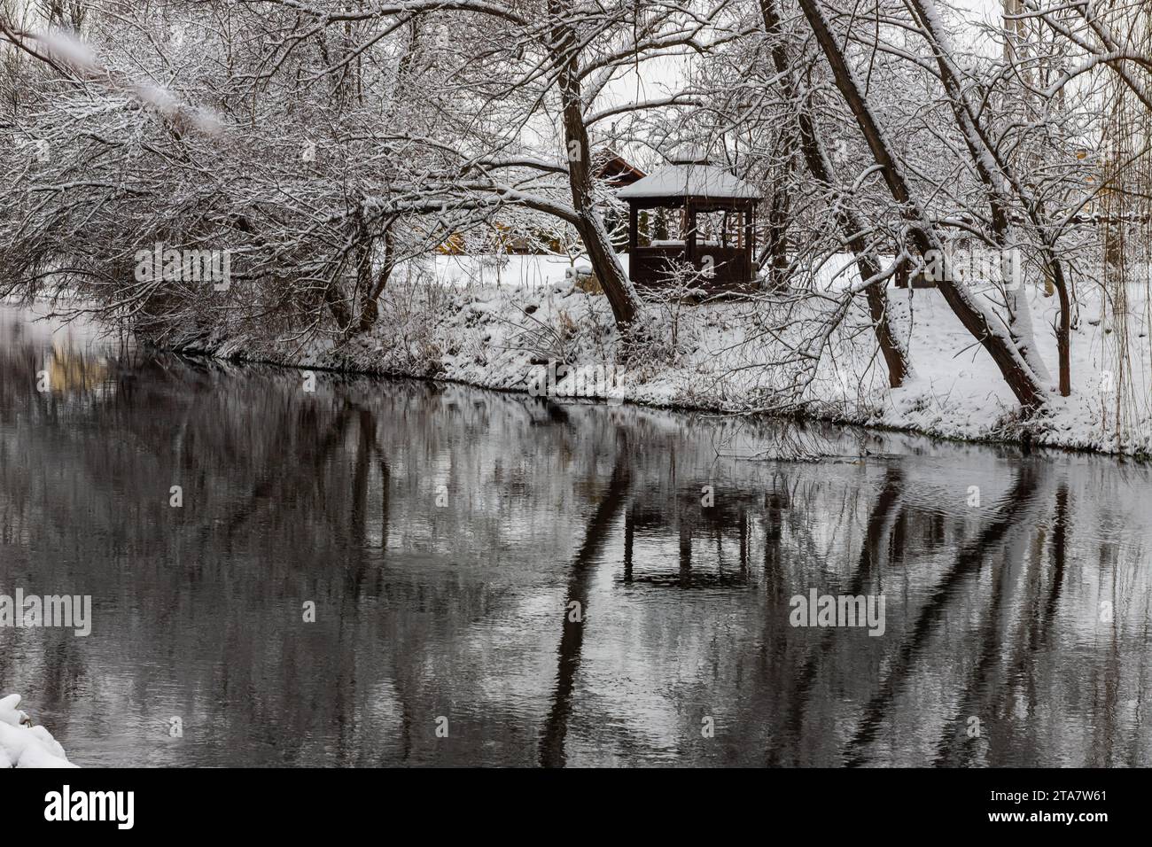 Un petit belvédère en bois dans les profondeurs d'une forêt d'hiver près d'un ruisseau de montagne froid et noyés marchent le long de lui, grimpant d'une vallée forestière. Banque D'Images