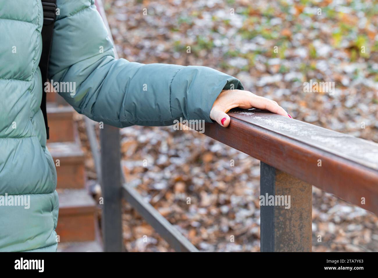 femme se tenant à la balustrade en bois descendant les escaliers. main tenant la main courante. Banque D'Images