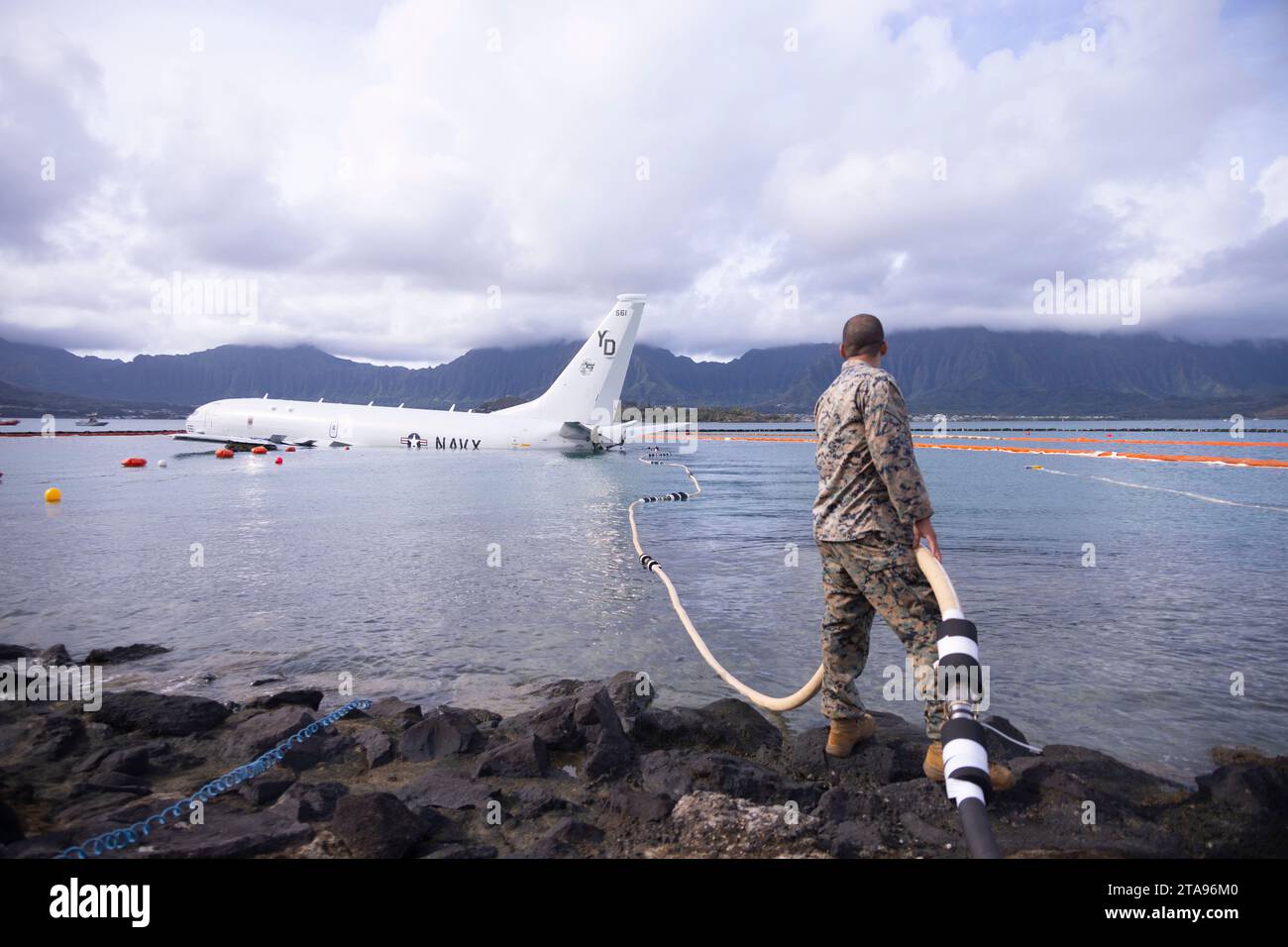 Kaneohe Bay, États-Unis. 26 novembre 2023. Un Marine des États-Unis tient un tuyau de carburant sécurisé lors des opérations de ravitaillement d'un avion P-8a Poseidon de l'US Navy abattu qui a dépassé la piste dans l'eau à la base aérienne du corps des Marines Kaneohe Bay, le 26 novembre 2023 dans la baie de Kaneohe, Hawaii. Crédit : Sgt. Brandon Aultman/É.-U. Marine corps/Alamy Live News Banque D'Images