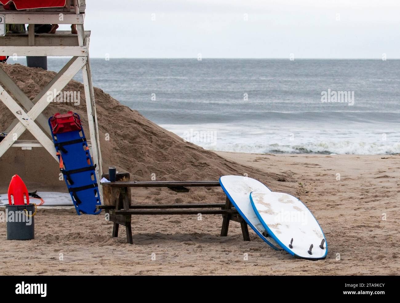 Une chaise de sauveteur et planche de surf sur une plage avec l'océan Atlantique en arrière-plan. Banque D'Images