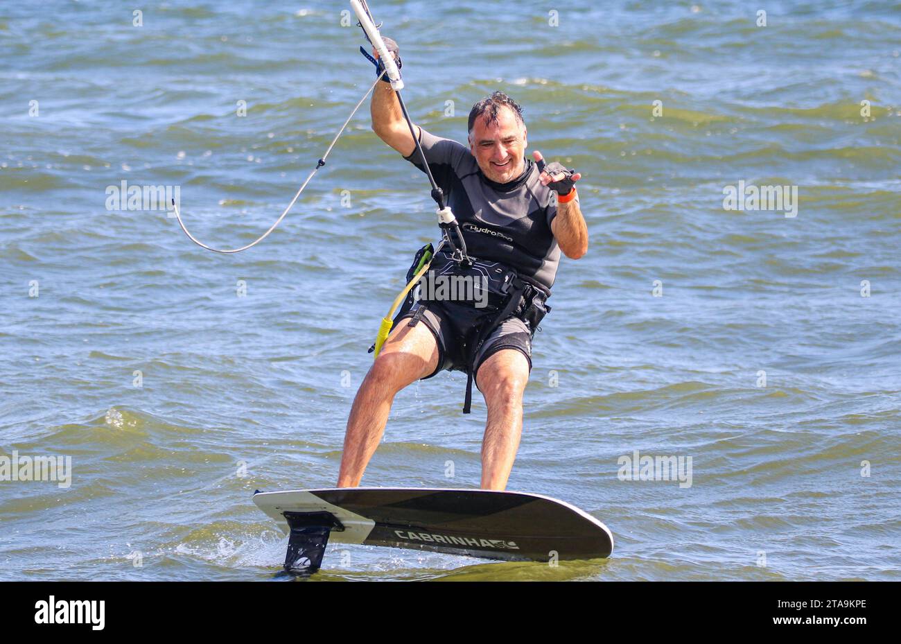 Gilgo, New York, États-Unis - 13 août 2023 : un homme monte une planche de kitesurf sur une étendue d'eau. Banque D'Images